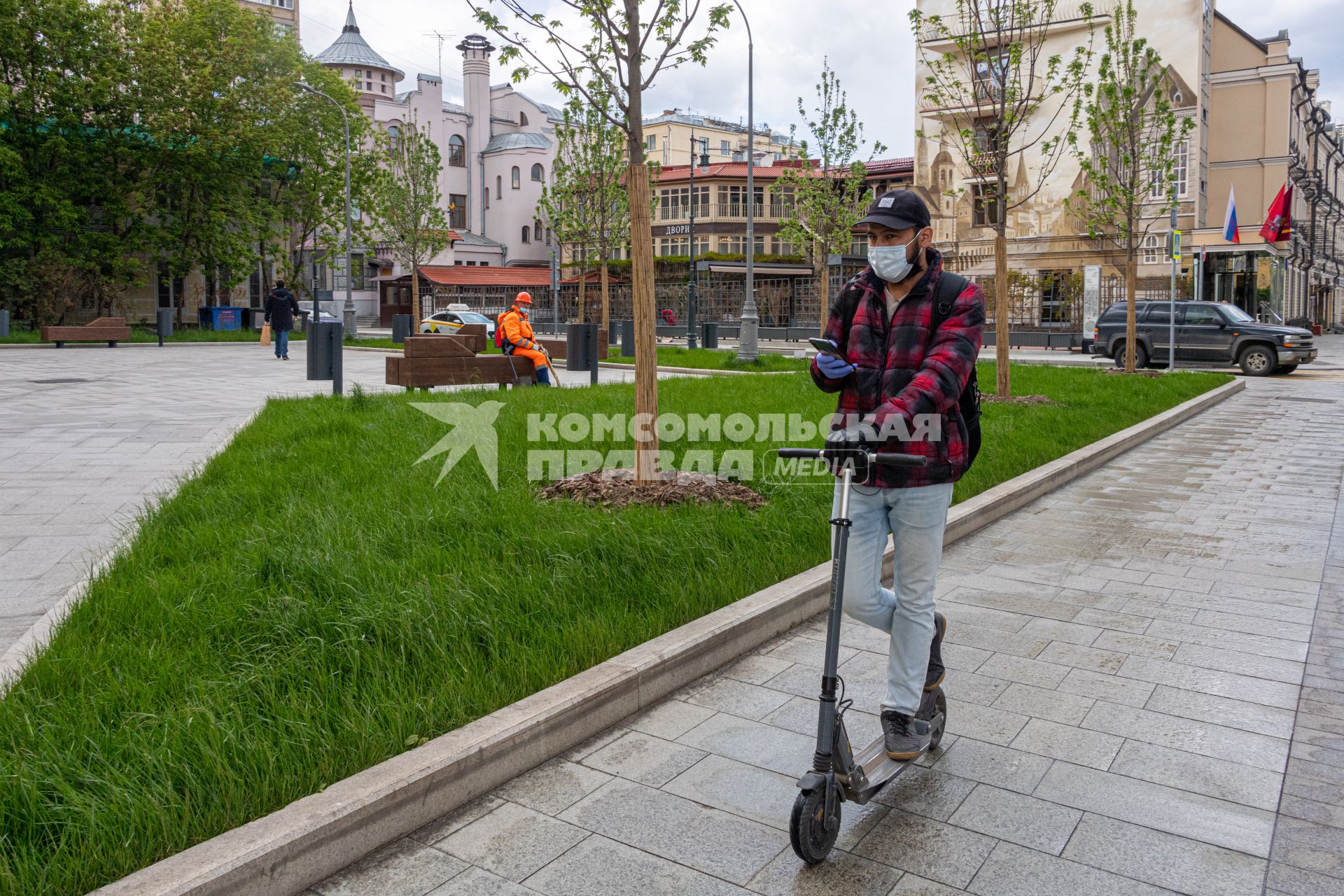 Москва. Мужчина в медицинской маске на самокате в районе улицы Остоженка.