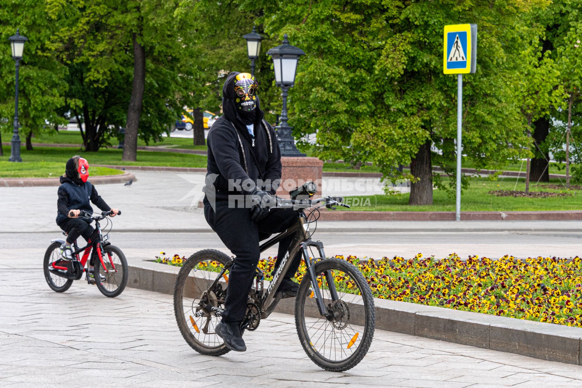 Москва. Мужчина с ребенком катается на велосипеде в Александровском саду.