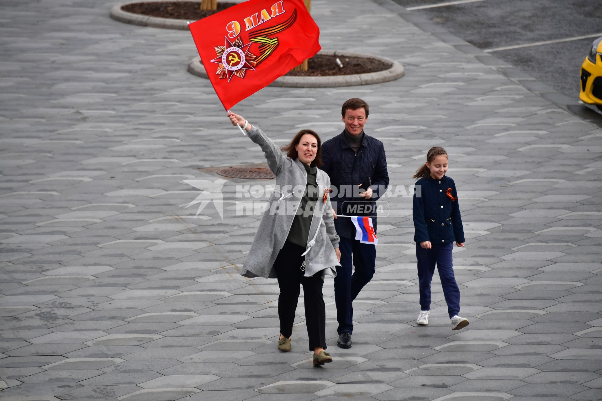 Москва. Прохожие с флагом  на Красной площади во время  воздушного парада Победы в Москве.