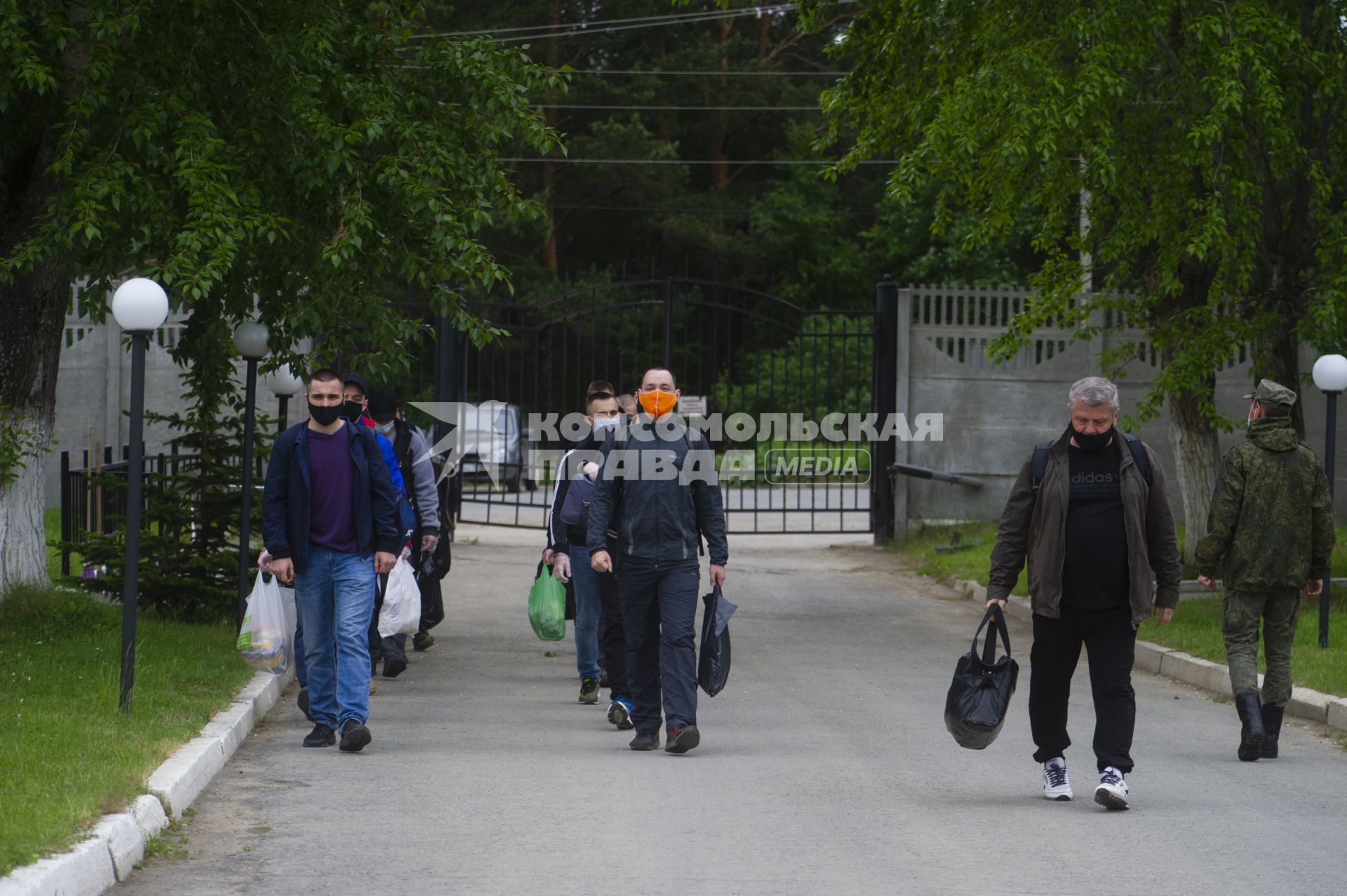 Свердловская область. Окружной сборный пункт (ОСП).  Во время призывной кампании, для нераспространения новой коронавирусной инфекции COVID-19 на территории ОСП введен особый противоэпидемический режим. На фото: группа призывников с личными вещами и в защитных масках на входе в ОСП