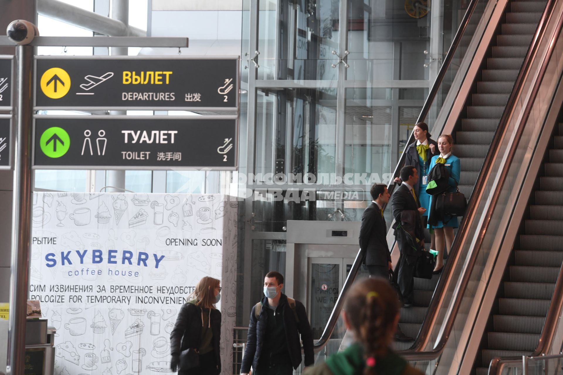 Москва.  Пассажиры на эскалаторе аэропорта Домодедово имени  Ломоносова во время пандемии коронавируса COVID-19.