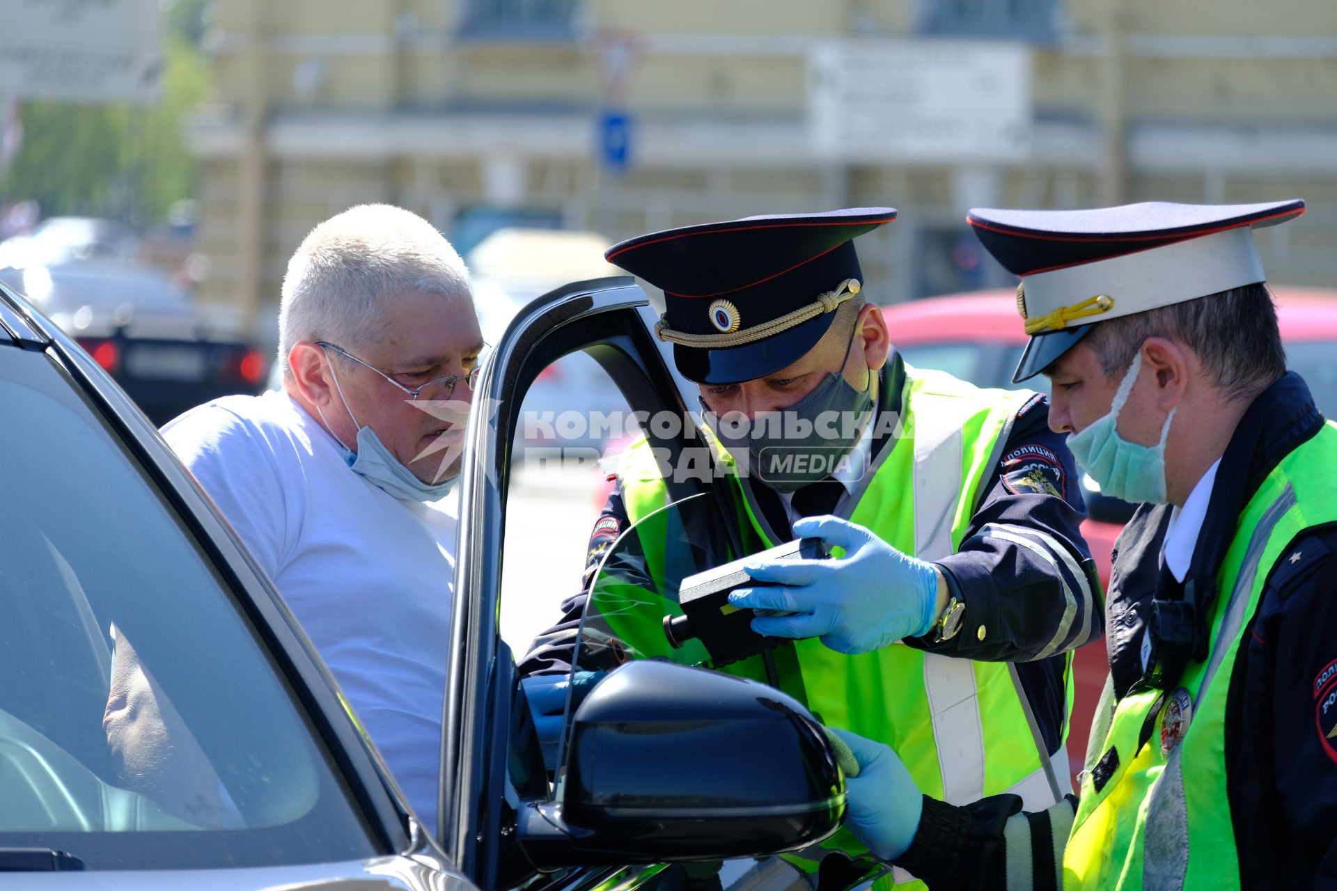 Санкт-Петербург. Инспектор ДПС проверяет тонировку стекла передней дверцы автомобиля.