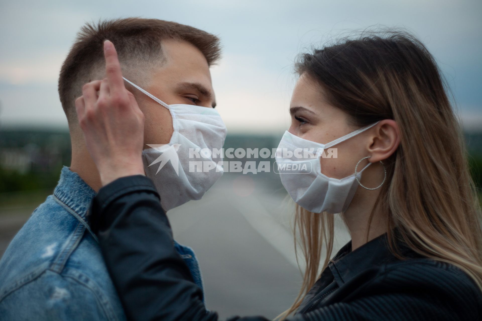 Пермь.  Молодой человек с девушкой в медицинских масках во время прогулки.