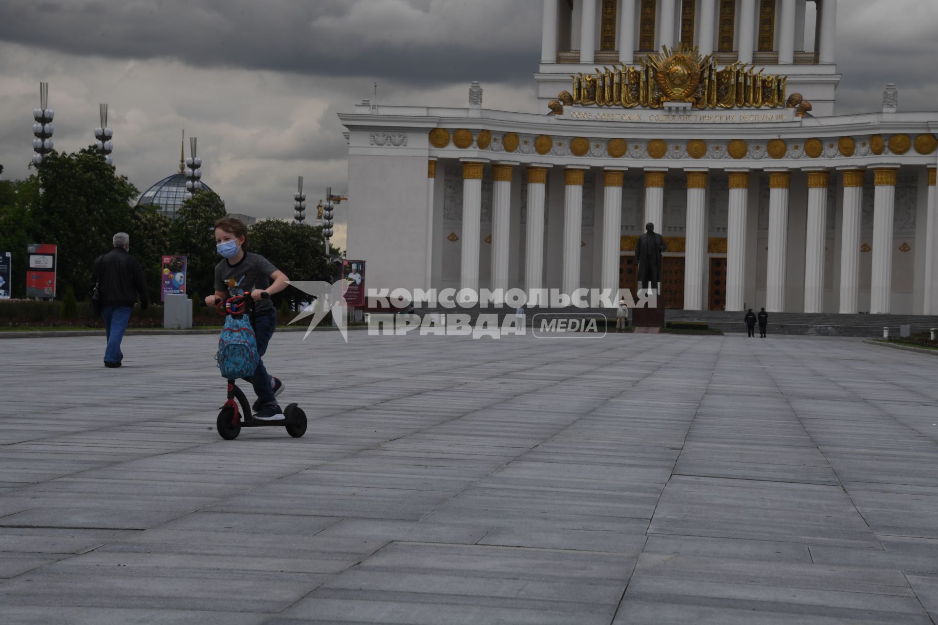 Москва.  Посетители катаются на самокатах на ВДНХ.