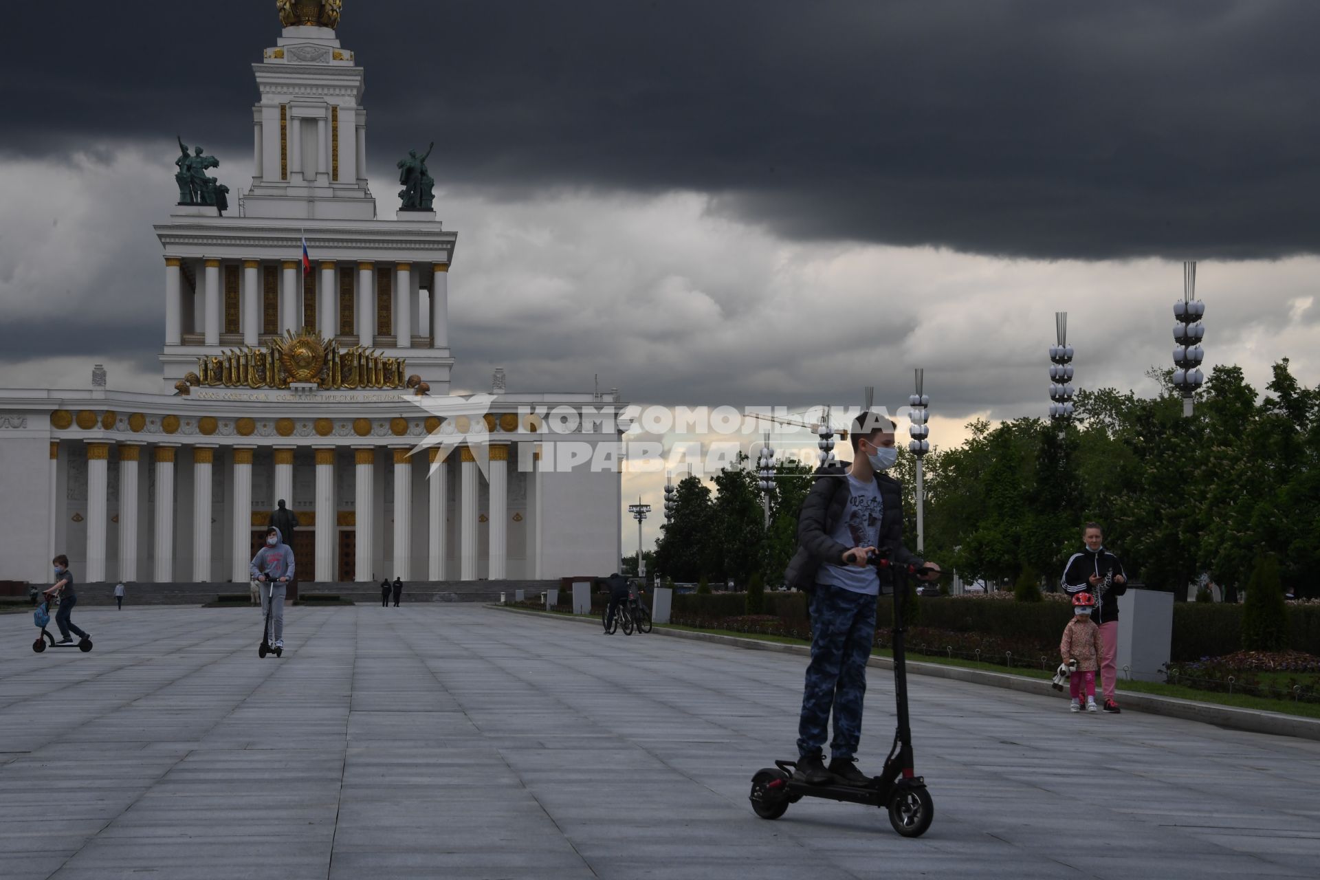 Москва.  Посетители катаются на самокатах на ВДНХ.