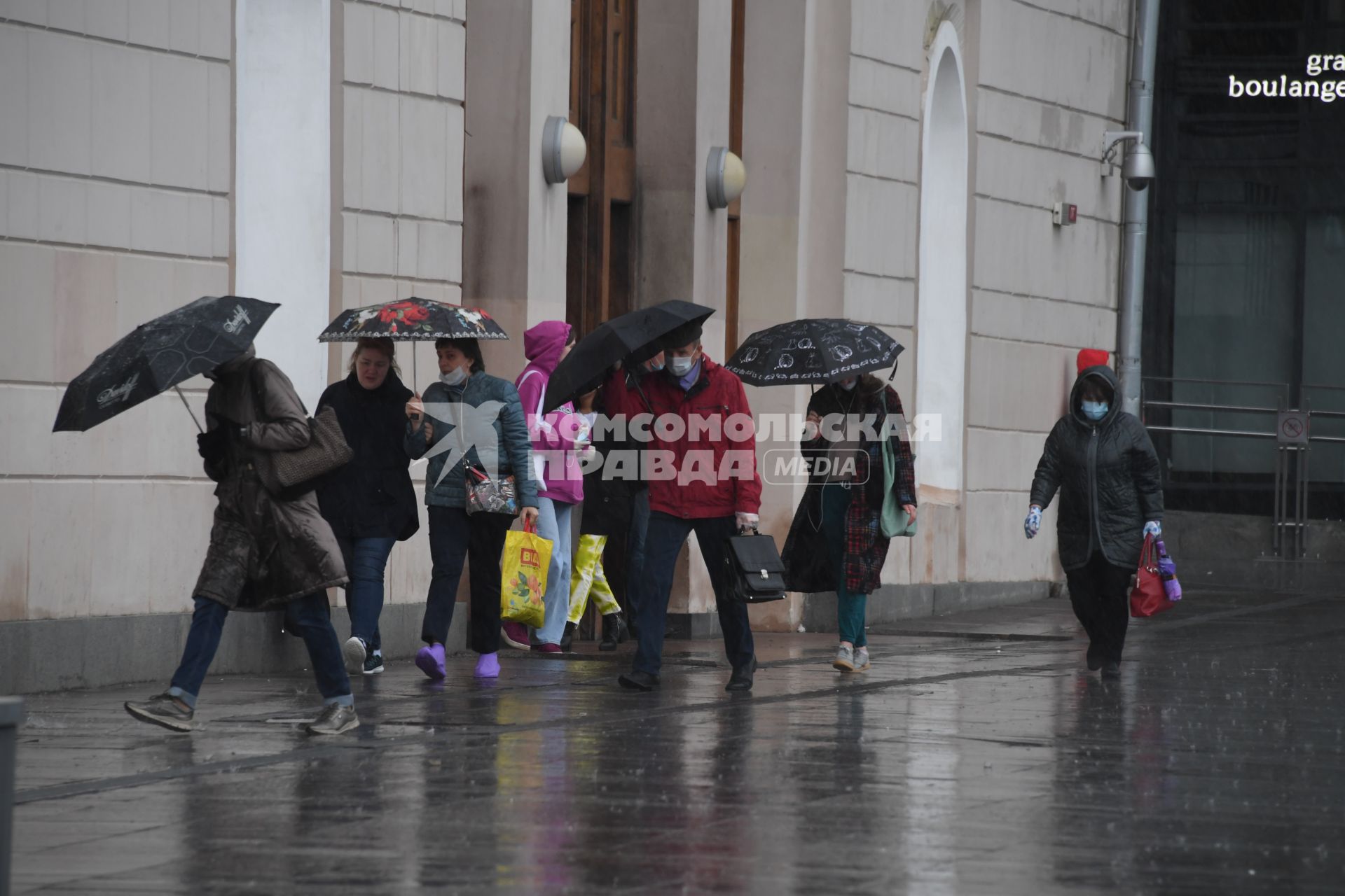 Москва.  Прохожие под дождем у метро Парк Культуры.