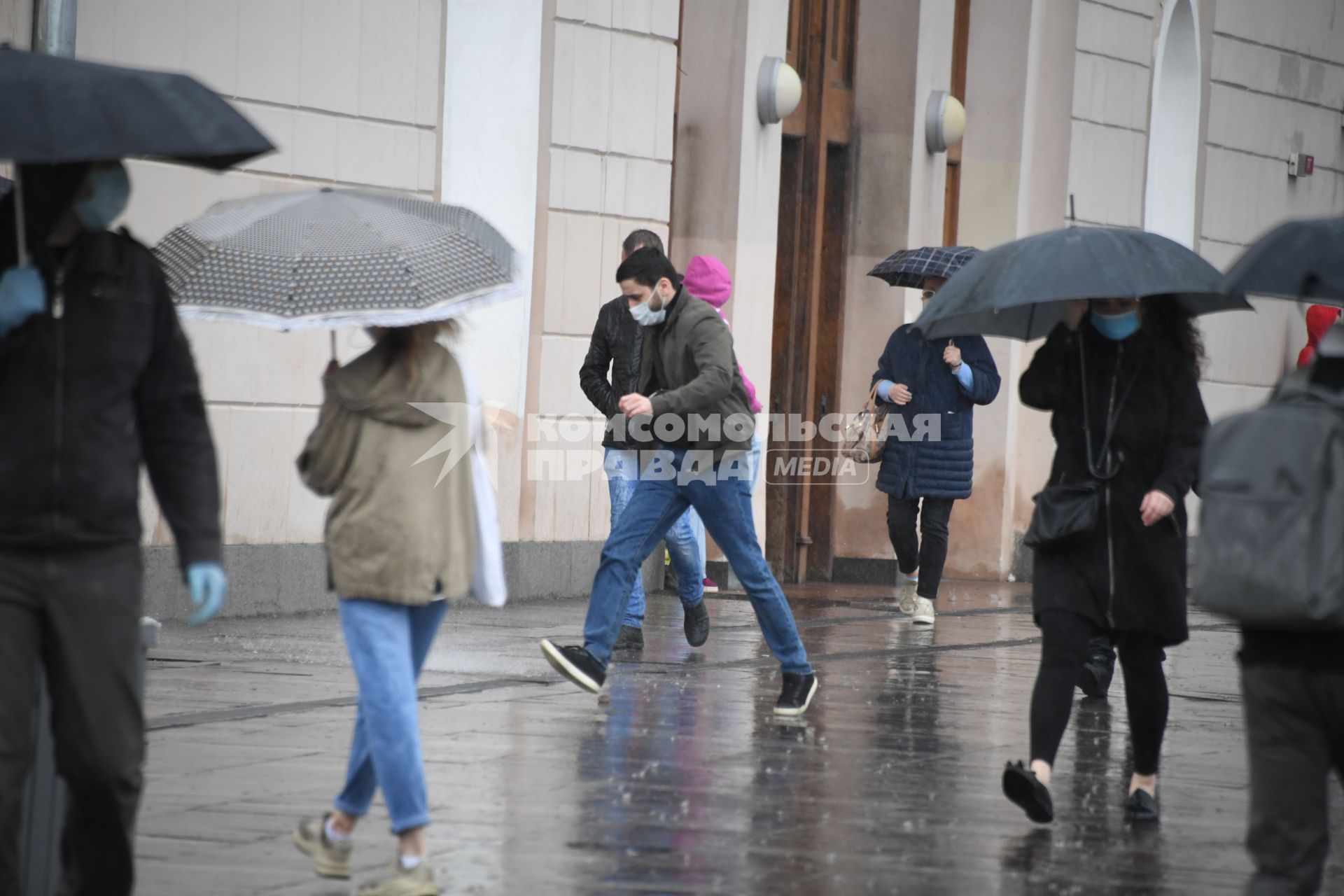 Москва.  Прохожие под дождем у метро Парк Культуры.