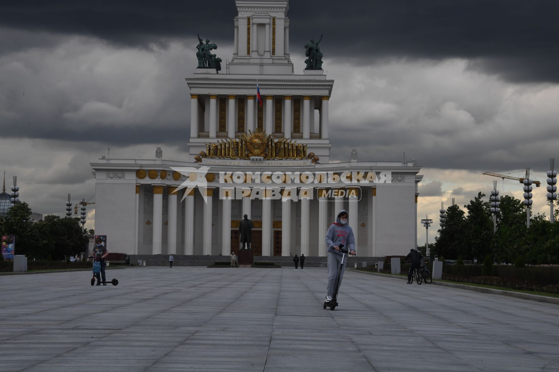 Москва.  Посетители катаются на самокатах на ВДНХ.