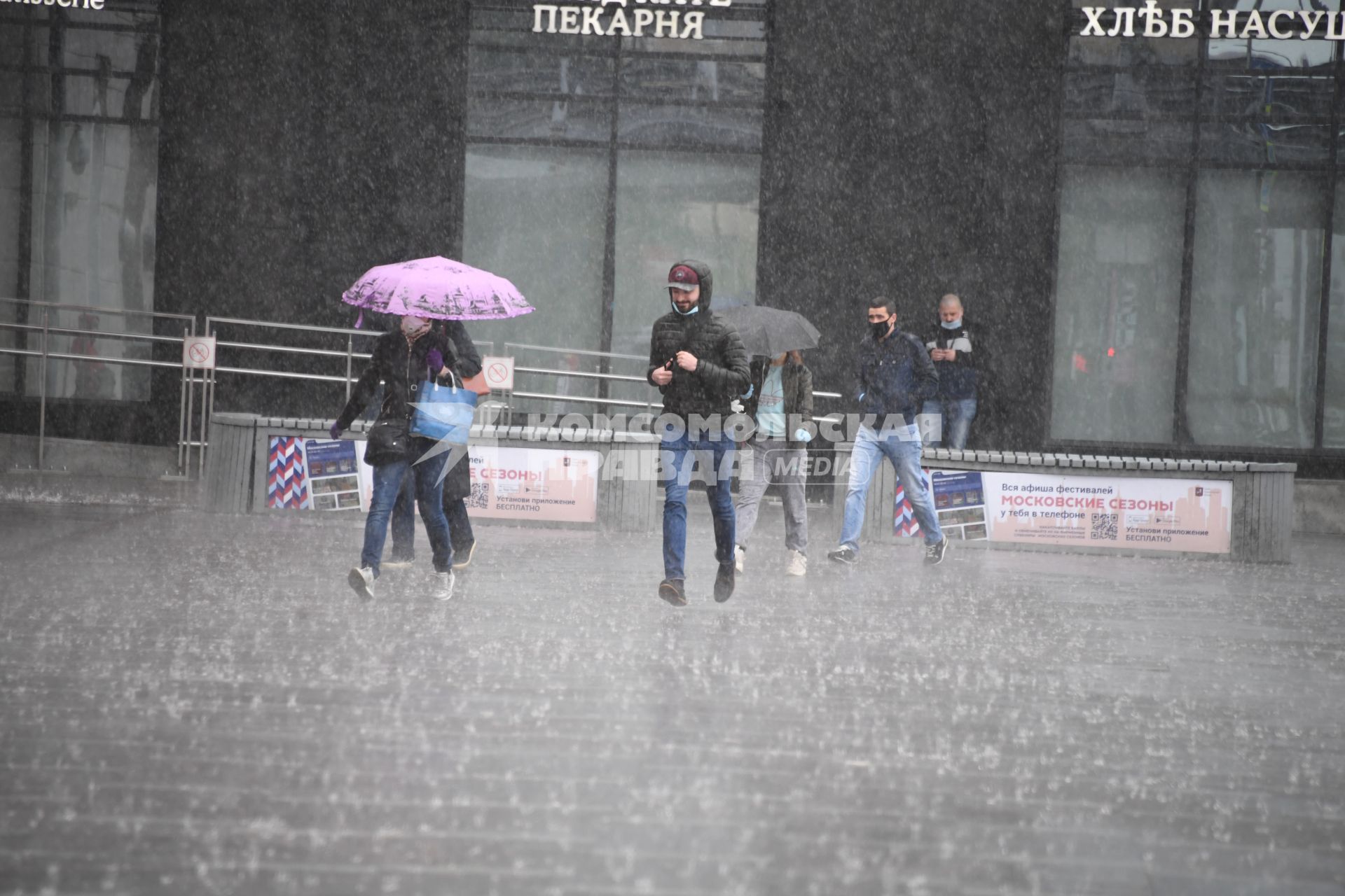 Москва.  Прохожие под дождем у метро Парк Культуры.