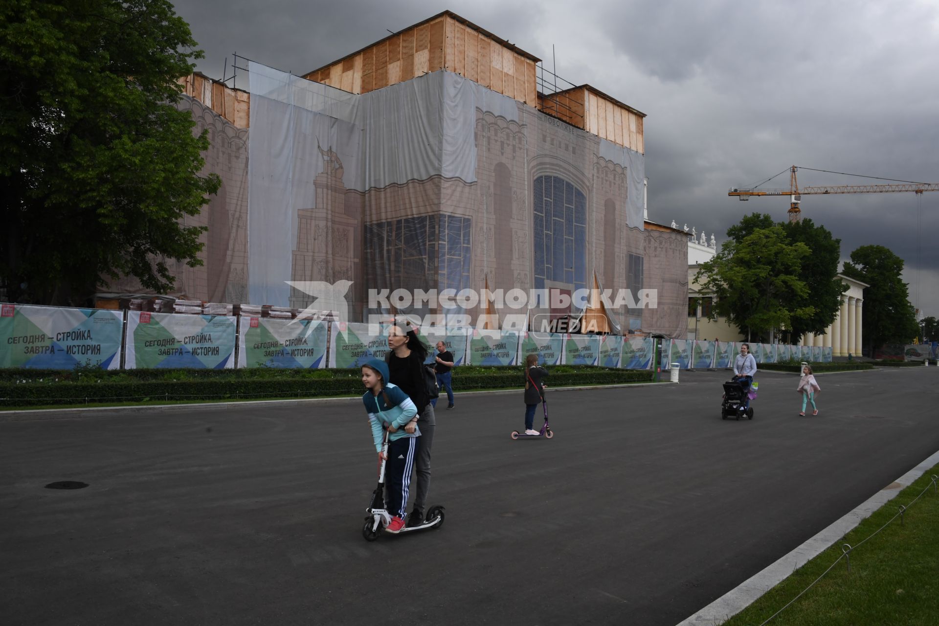 Москва.  Посетители катаются на самокатах по аллеям ВДНХ.