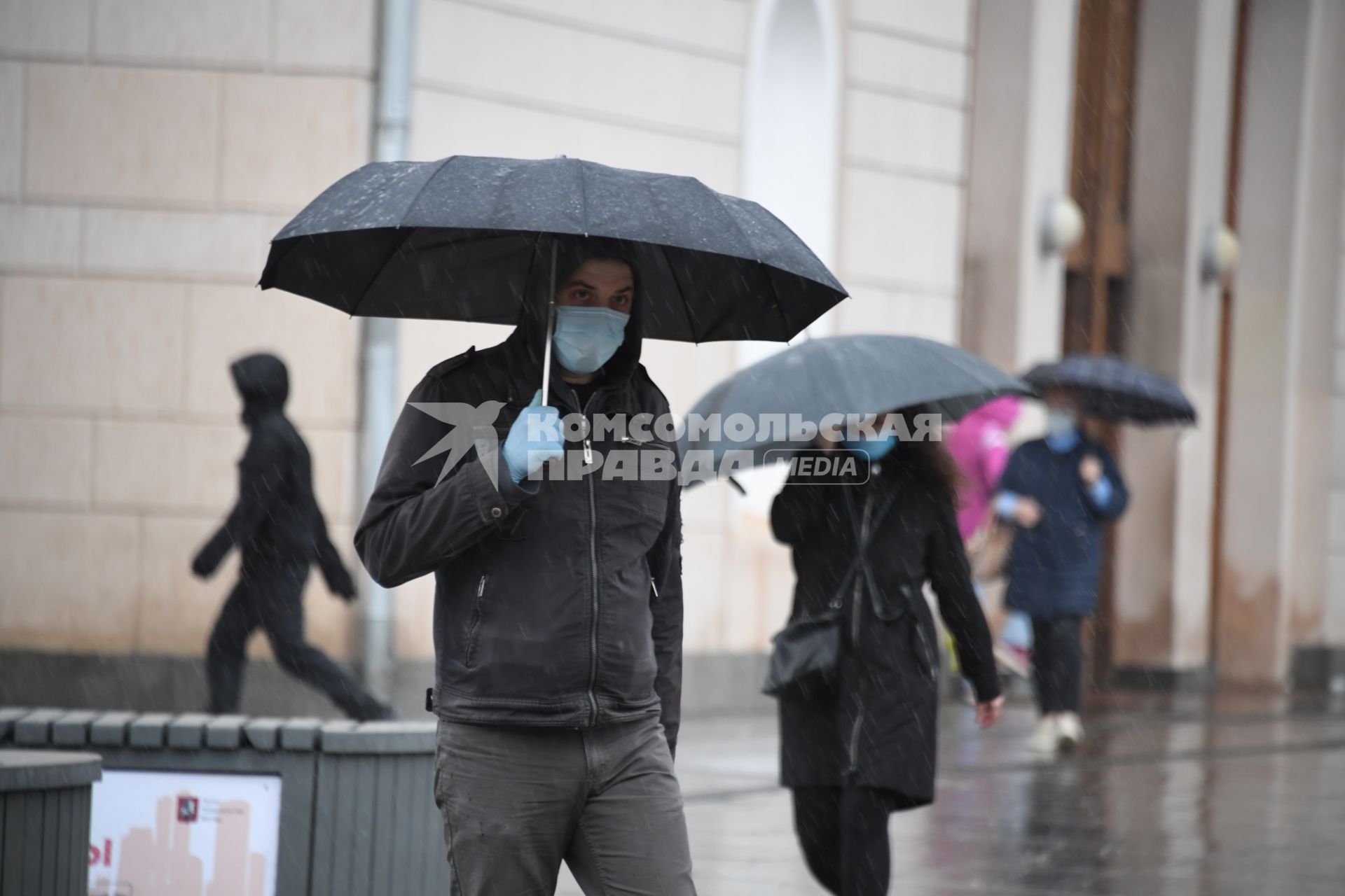 Москва.  Прохожие под дождем у метро Парк Культуры.