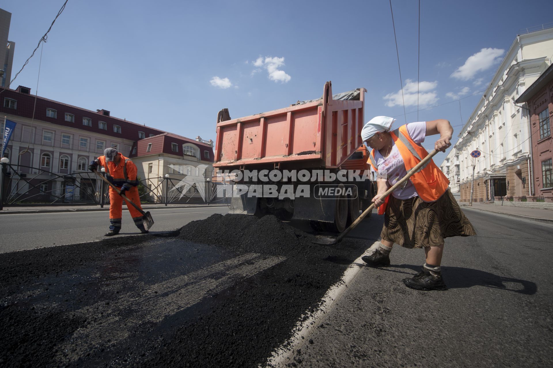 Екатеринбург. Дорожная рабочая-женщина укладывает асфальт на ремонтируемой дороге