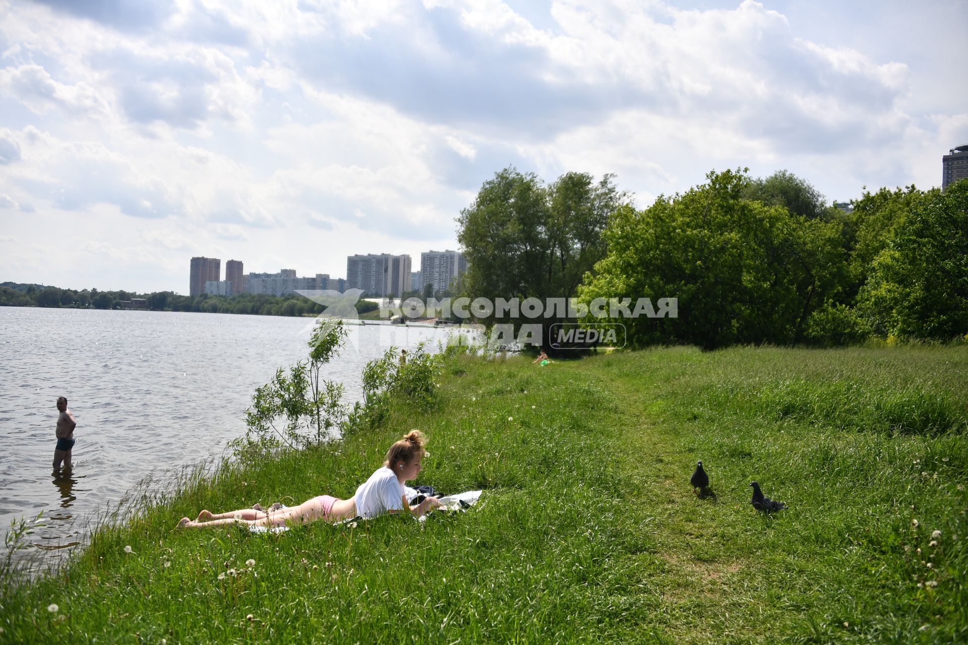 Москва. Девушка загорает на пляже в Строгинской пойме.