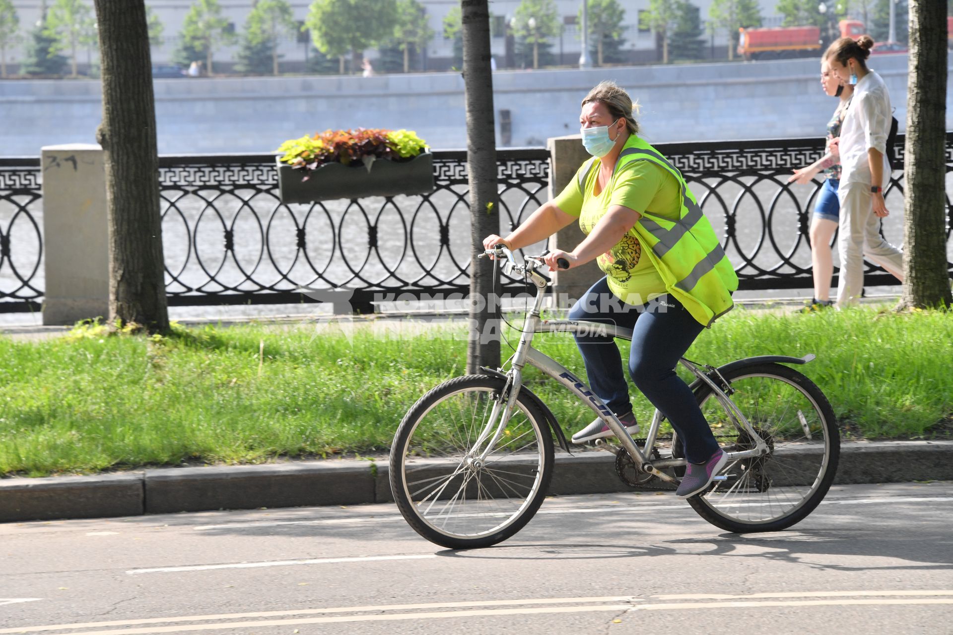 Москва.  Женщина в медицинской маске на велосипеде в парке Горького после отмены режима самоизоляции, введенного  из-за пандемии коронавируса.