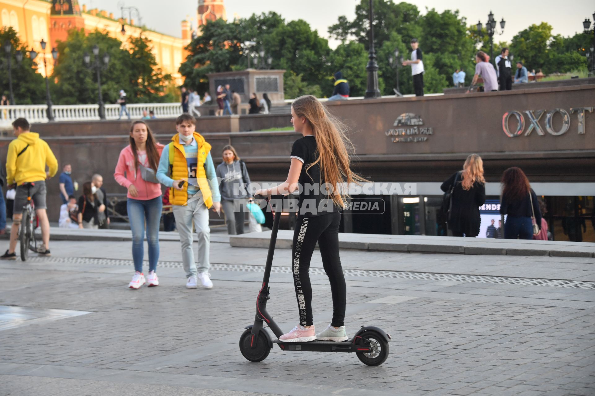 Москва.  Девушка на электросамокате на Манежной площади.