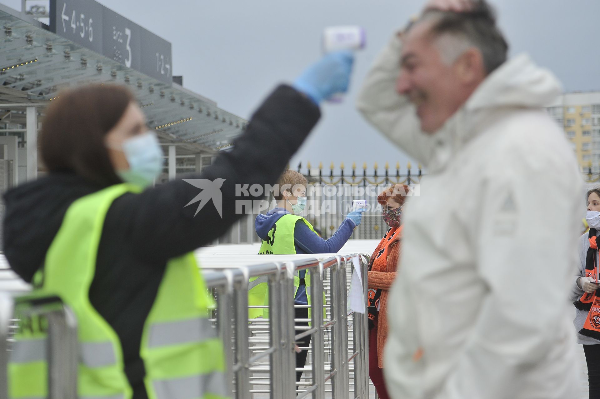 Екатеринбург. Волонтер измеряющяет температуру тела у болельщиков на входе на футбольный стадион \'Екатеринбург-арена\' перед началом матча премьер-лиги \'Урал\' 1-2 \'Рубин\'. Из-за эпидемии новой коронавирусной инфекции проведение футбольных матчей было запрещено, после ослабления противоэпидемического режима, было разрешено проводить массовые мероприятия при условии соблюдения противоэпидемических мер