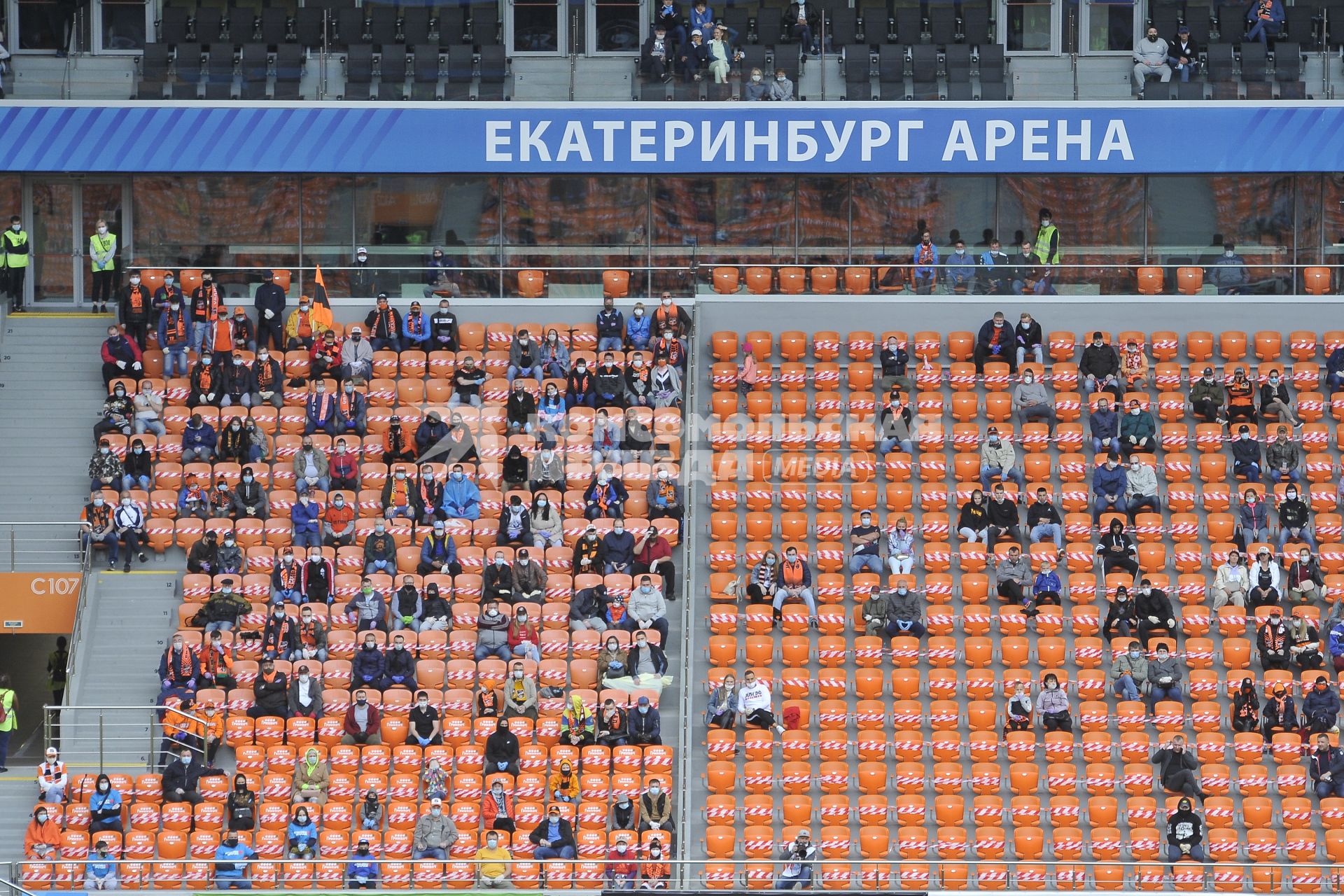 Екатеринбург. Болельщики на трибунах футбольного стадиона \'Екатеринбург-арена\' с широкой рассадкой болельщков для соблюдения 1.5 метровой социальной дистанции,  перед началом матча премьер-лиги \'Урал\' 1-2 \'Рубин\'. Из-за эпидемии новой коронавирусной инфекции проведение футбольных матчей было запрещено, после ослабления противоэпидемического режима, было разрешено проводить массовые мероприятия при условии соблюдения противоэпидемических мер