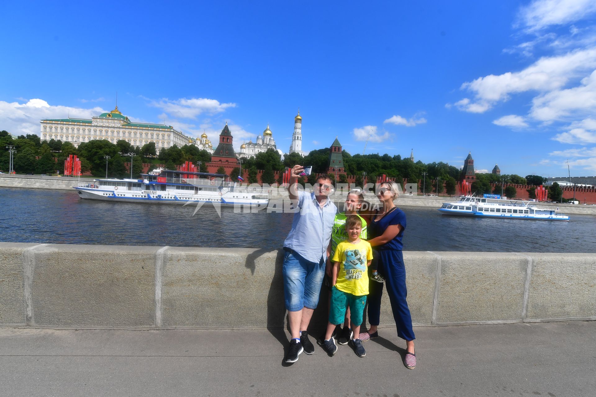 Москва. Прохожие фотографируются на Софийской набережной.