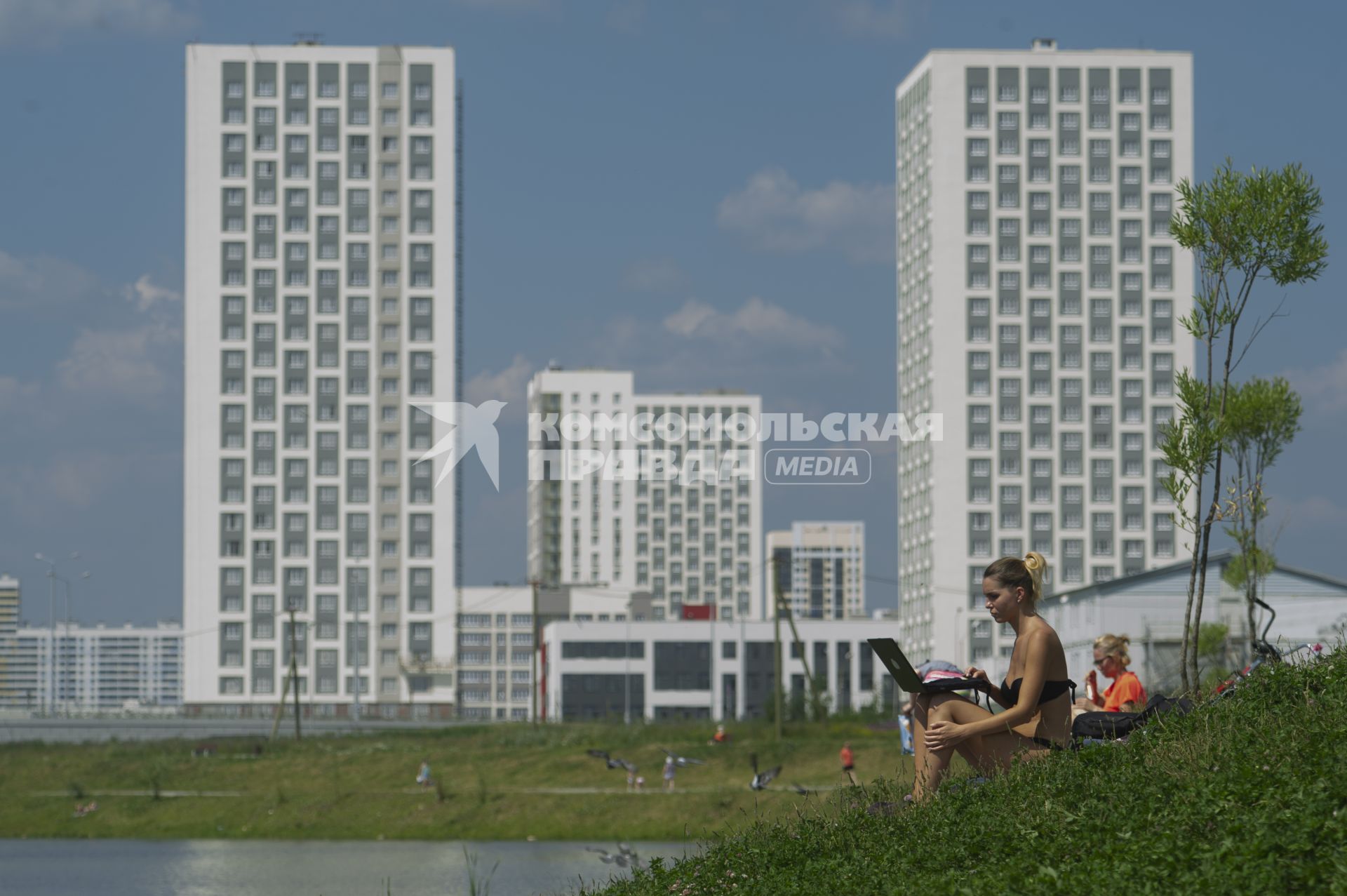 Екатеринбург. Новый жилой район \'Академический\'. Девушка в купальнике с ноутбуком загарает в преображенском парке