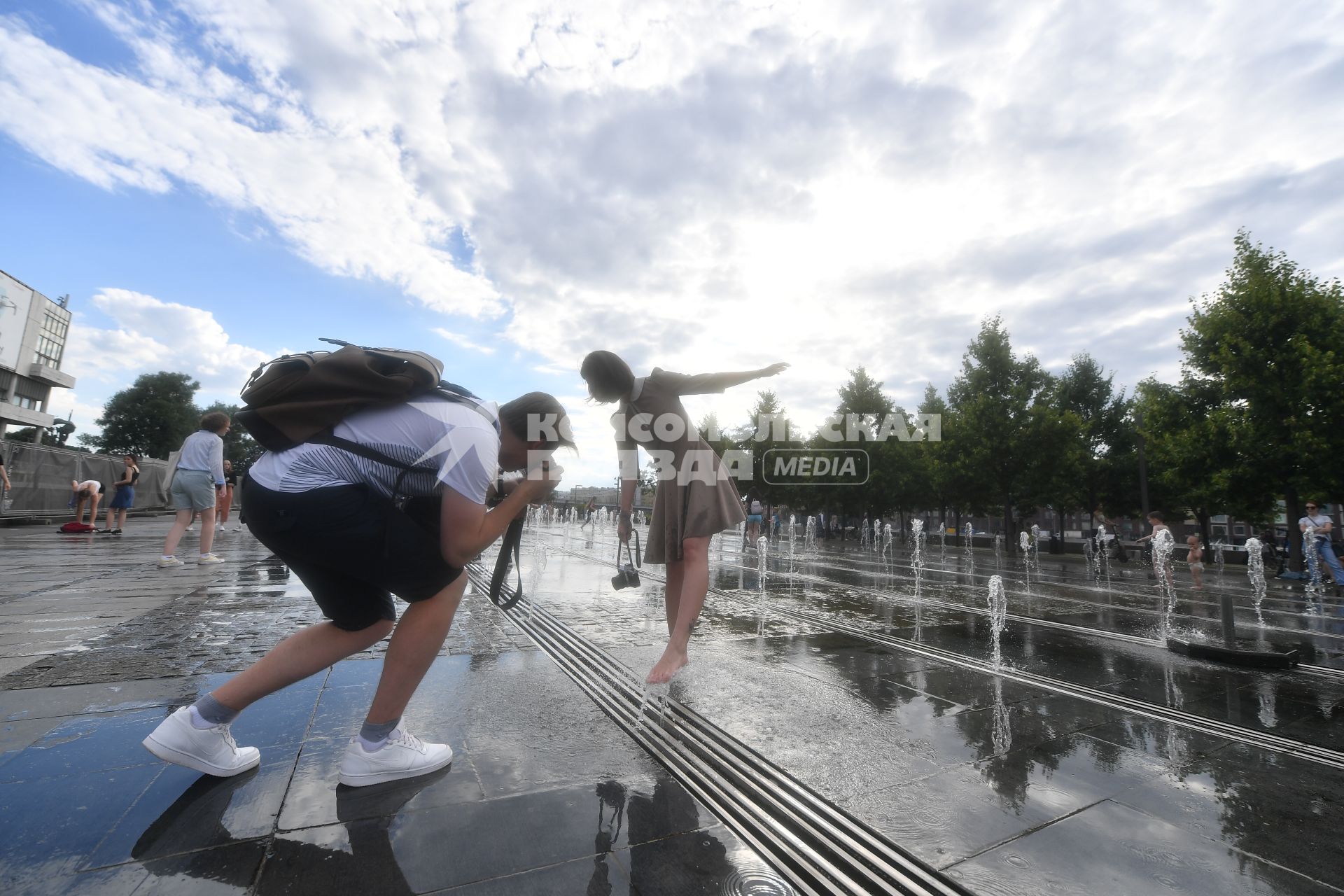 Москва. Молодые люди фотографируются у фонтанов парка Музеон.