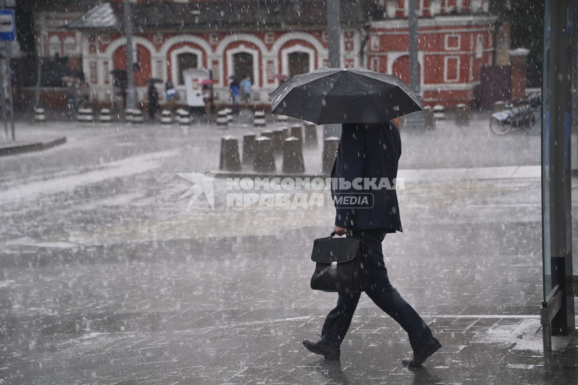 Москва.  Мужчина под зонтом на пешеходном переходе.