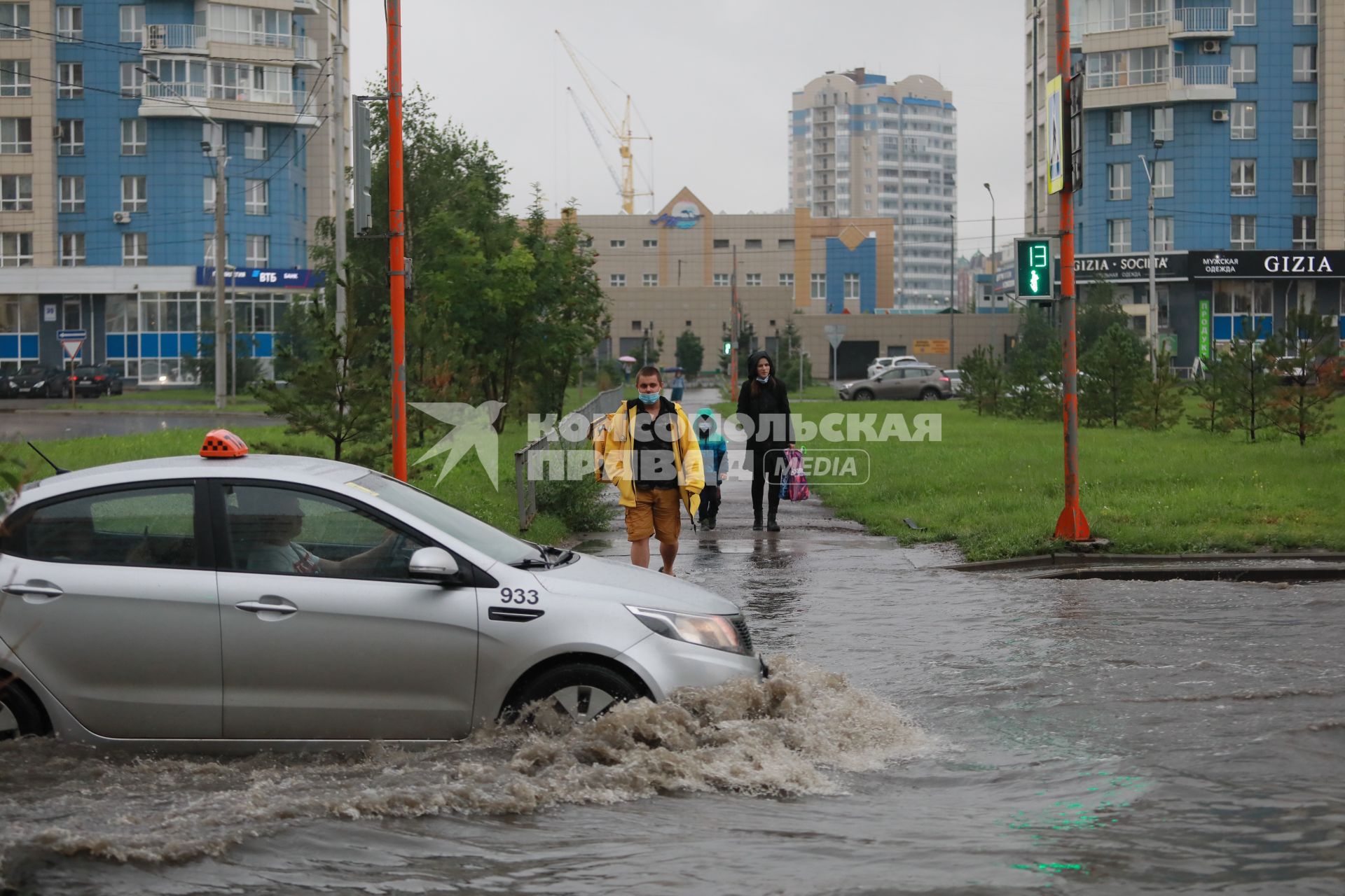 Красноярск. Машины едут по лужам во время дождя.