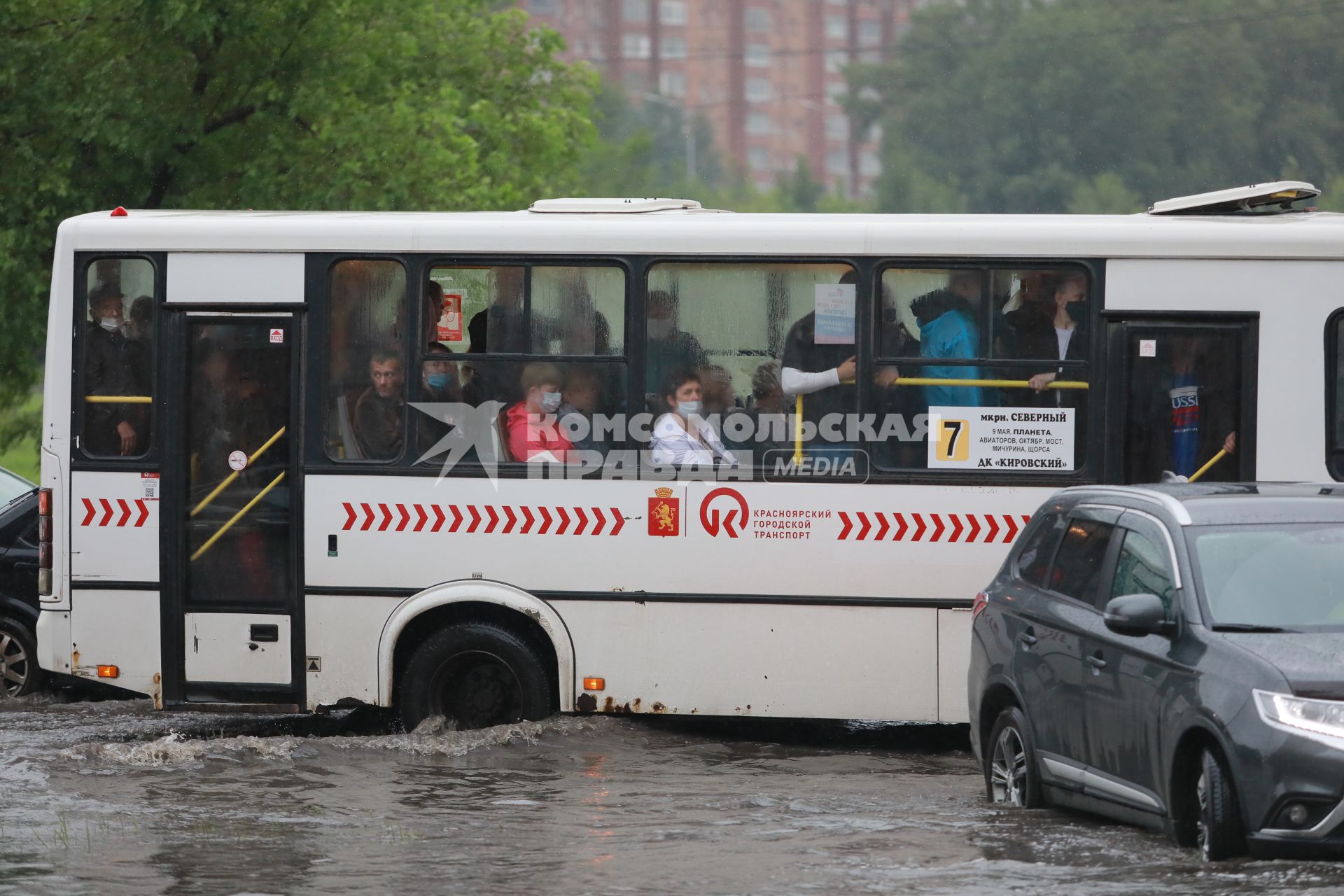 Красноярск. Машины едут по лужам во время дождя.