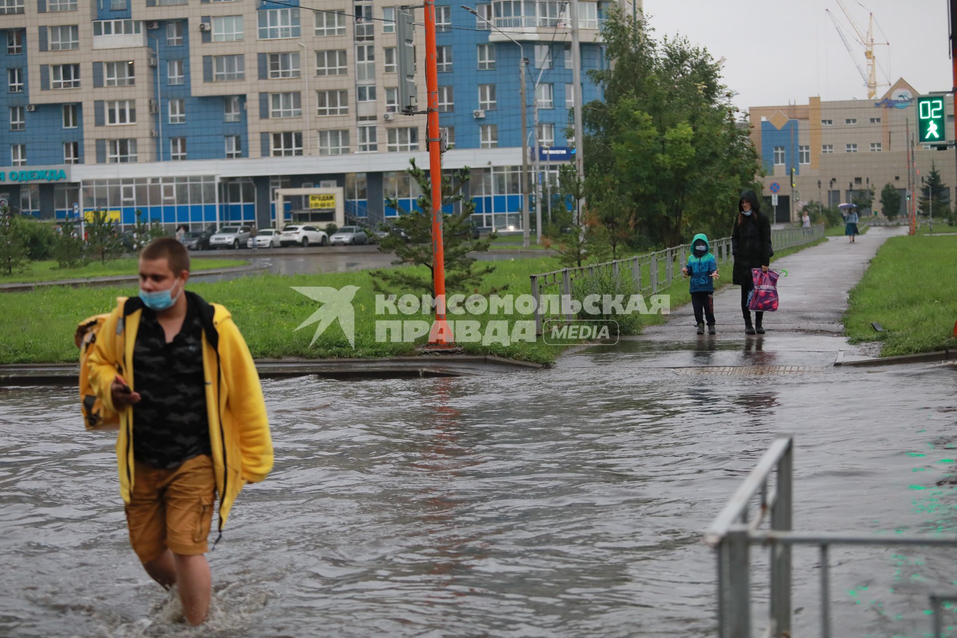 Красноярск. Пешеходы переходят  затопленную улицу.