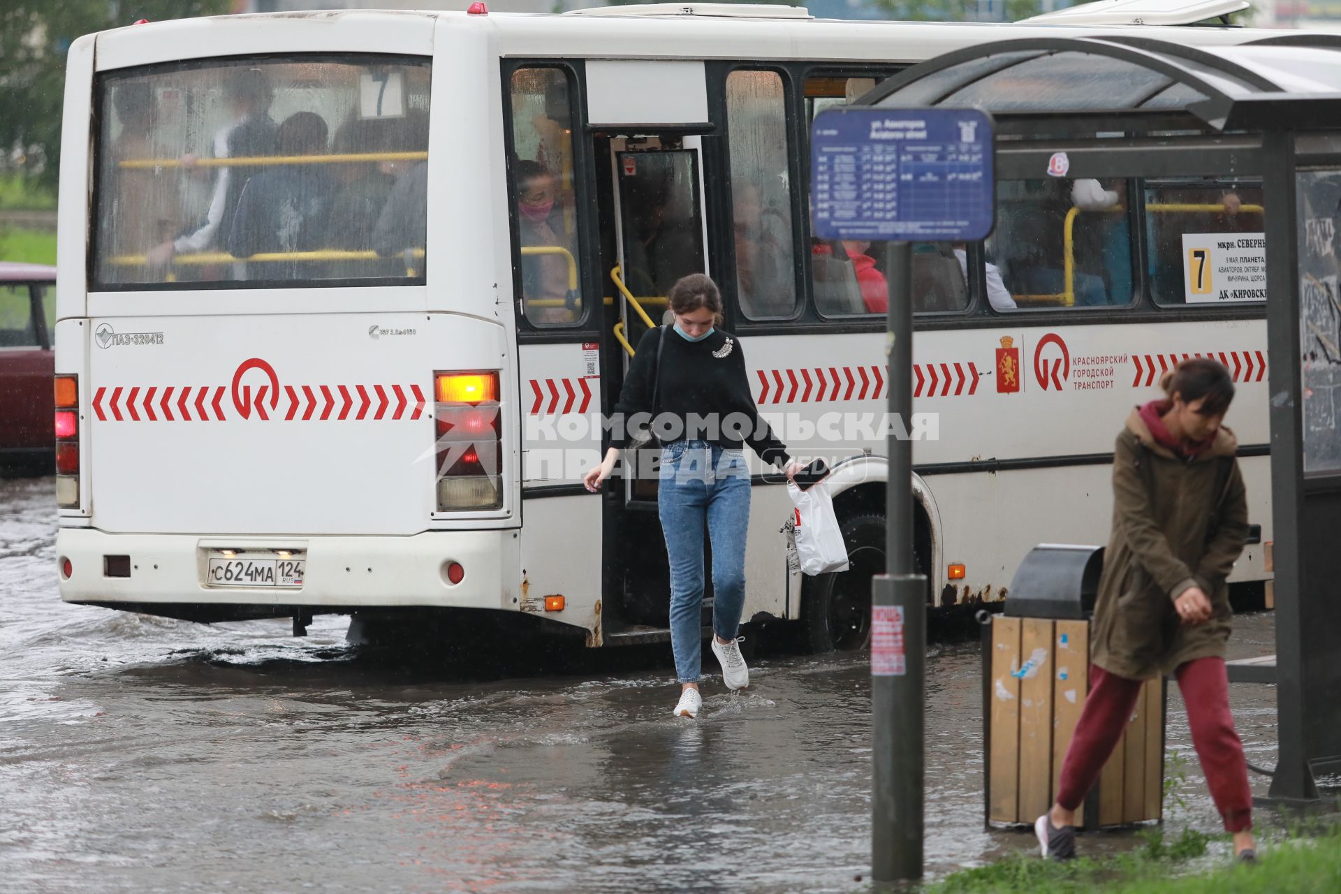 Красноярск. Пешеходы идут по лужам во время дождя.