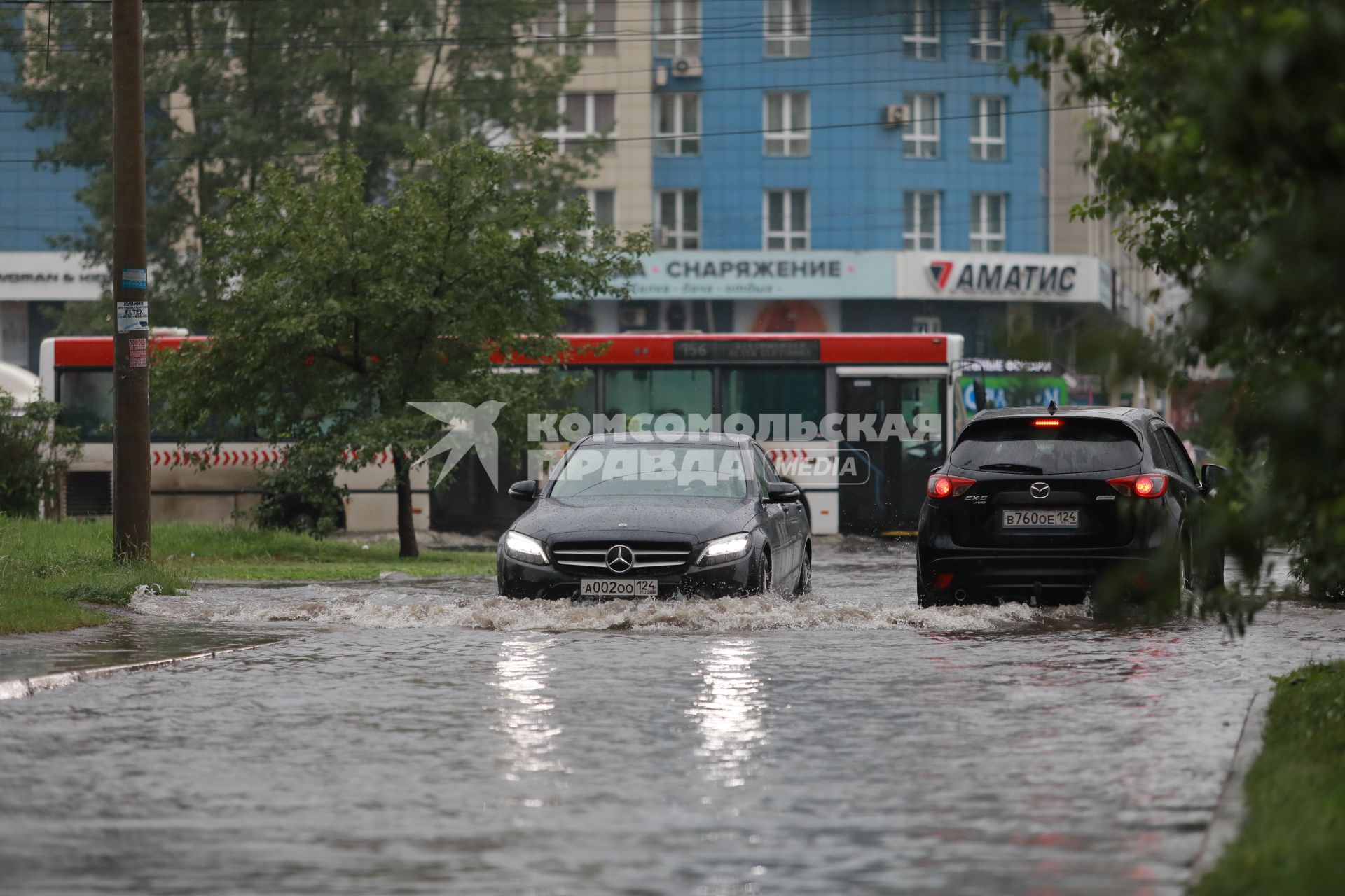 Красноярск. Машины едут по лужам во время дождя.