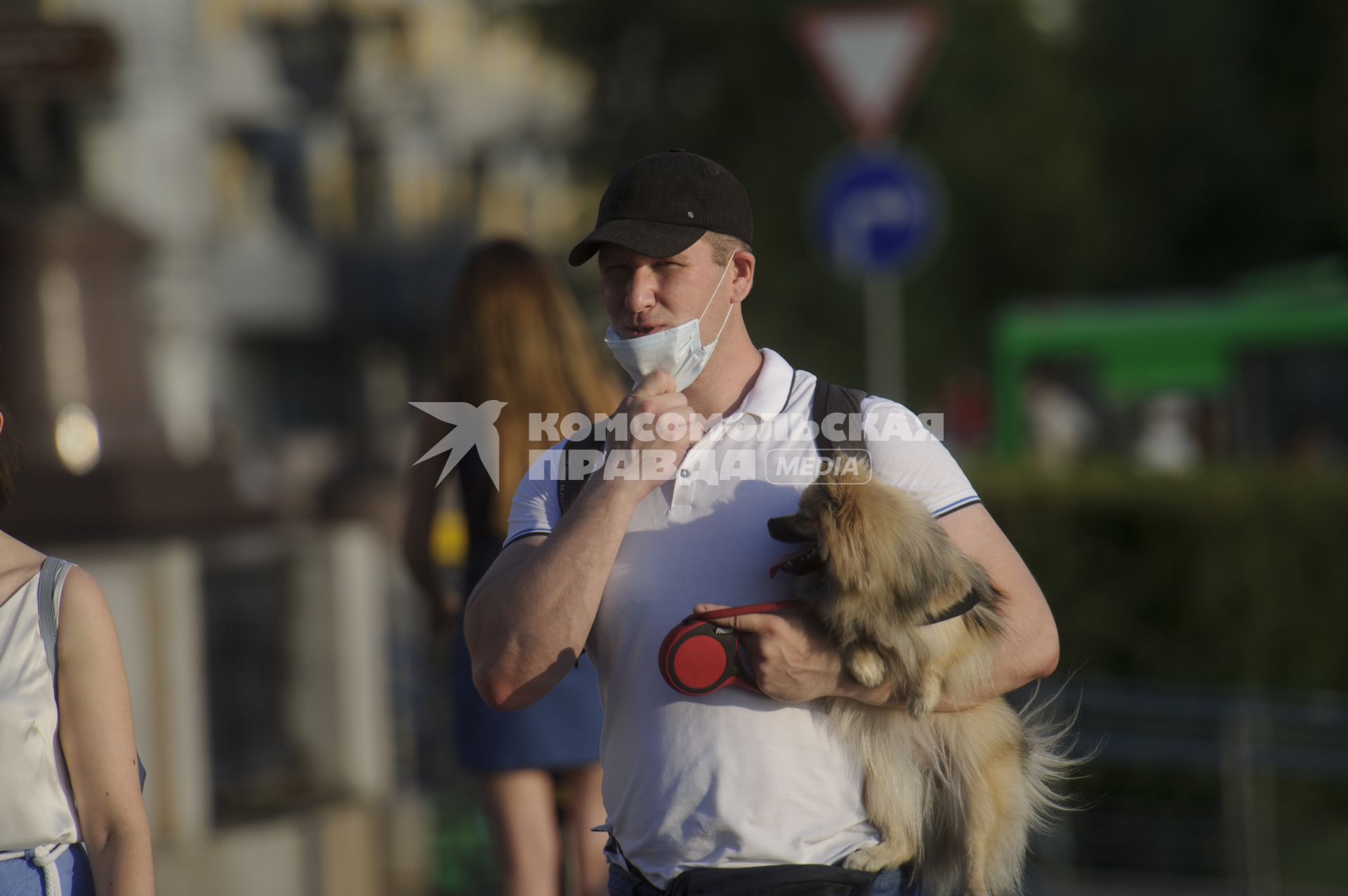 Екатеринбург. Мужчина в медицинской маске с собачкой на руках на набережной реки Исеть во время летней жары