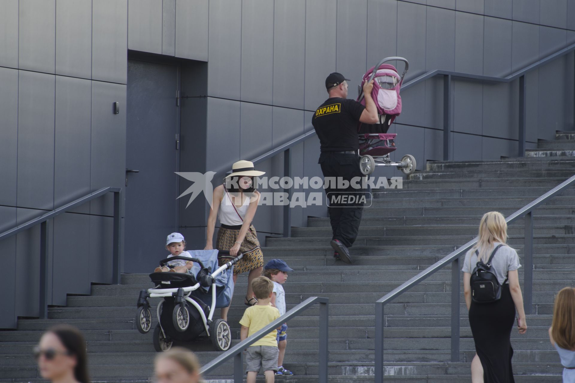 Екатеринбург. Охранник помогает женщине поднять детскую коляску по лестнице
