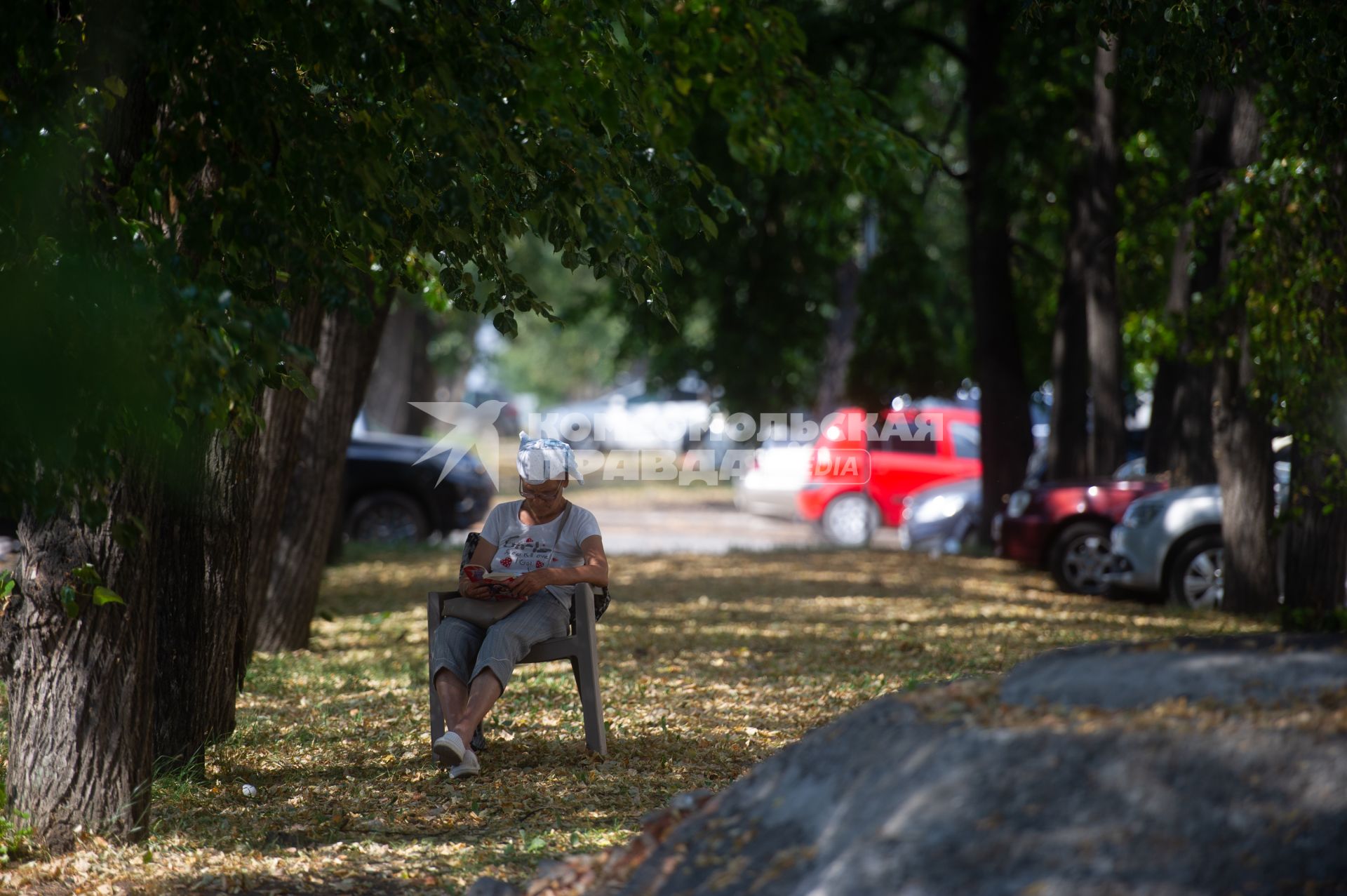 Екатеринбург. Пенсионерка сидит в тени деревьев  в парке, во время аномальной жары
