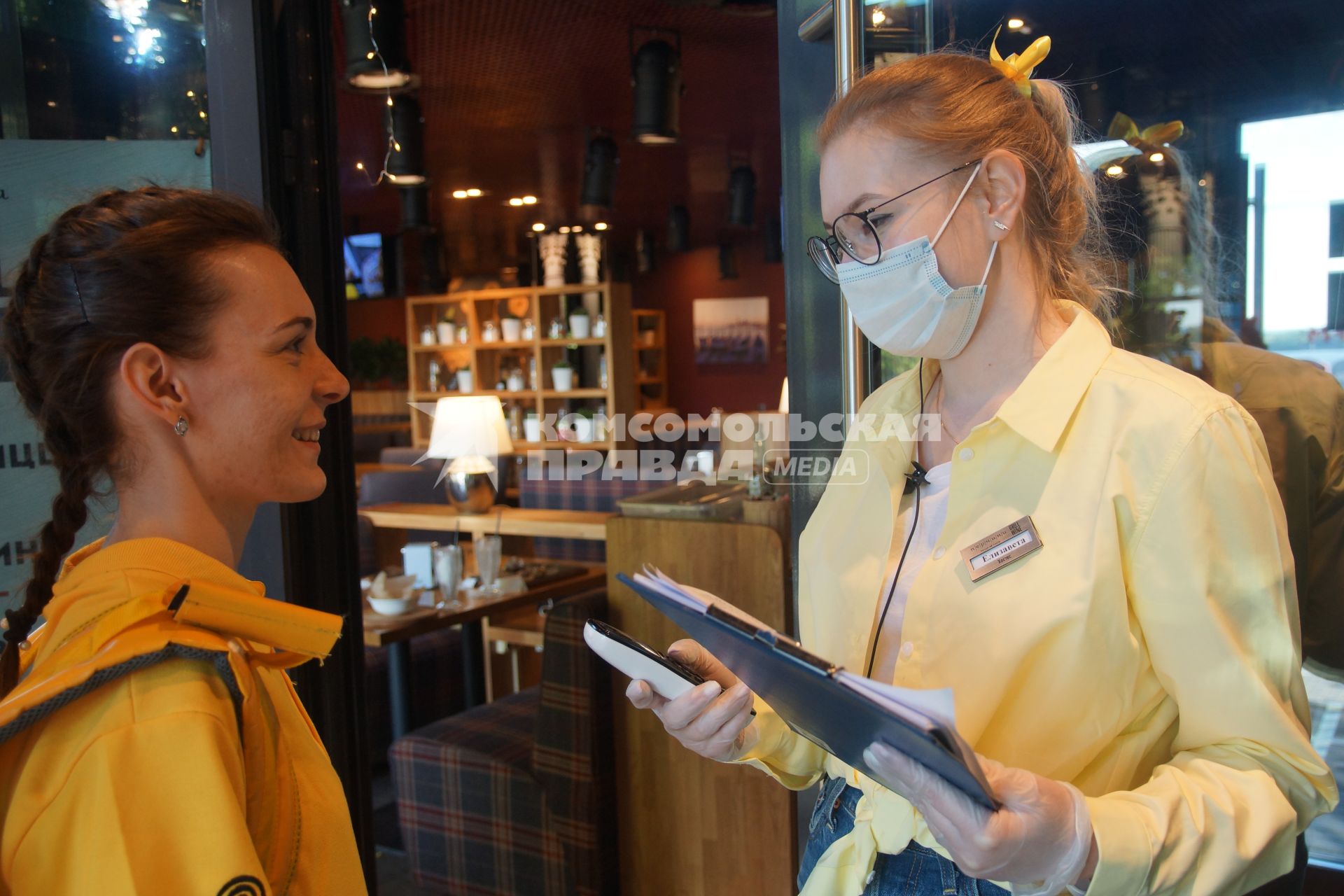 Самара. Девушка официантка   медицинской маске и посетительница кафе.