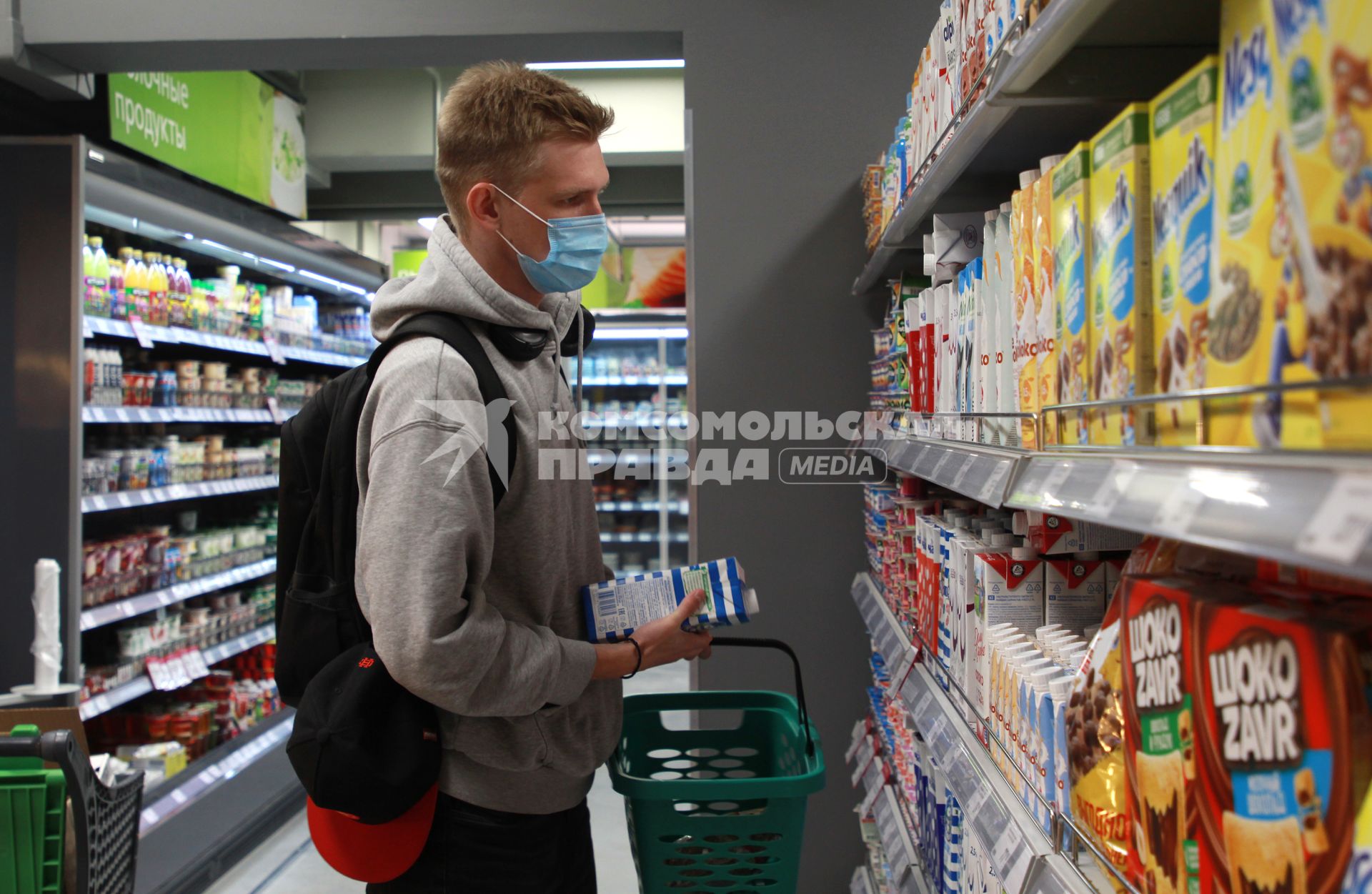 Иркутск.   Молодой человек в медицинской маске в продуктовом магазине.