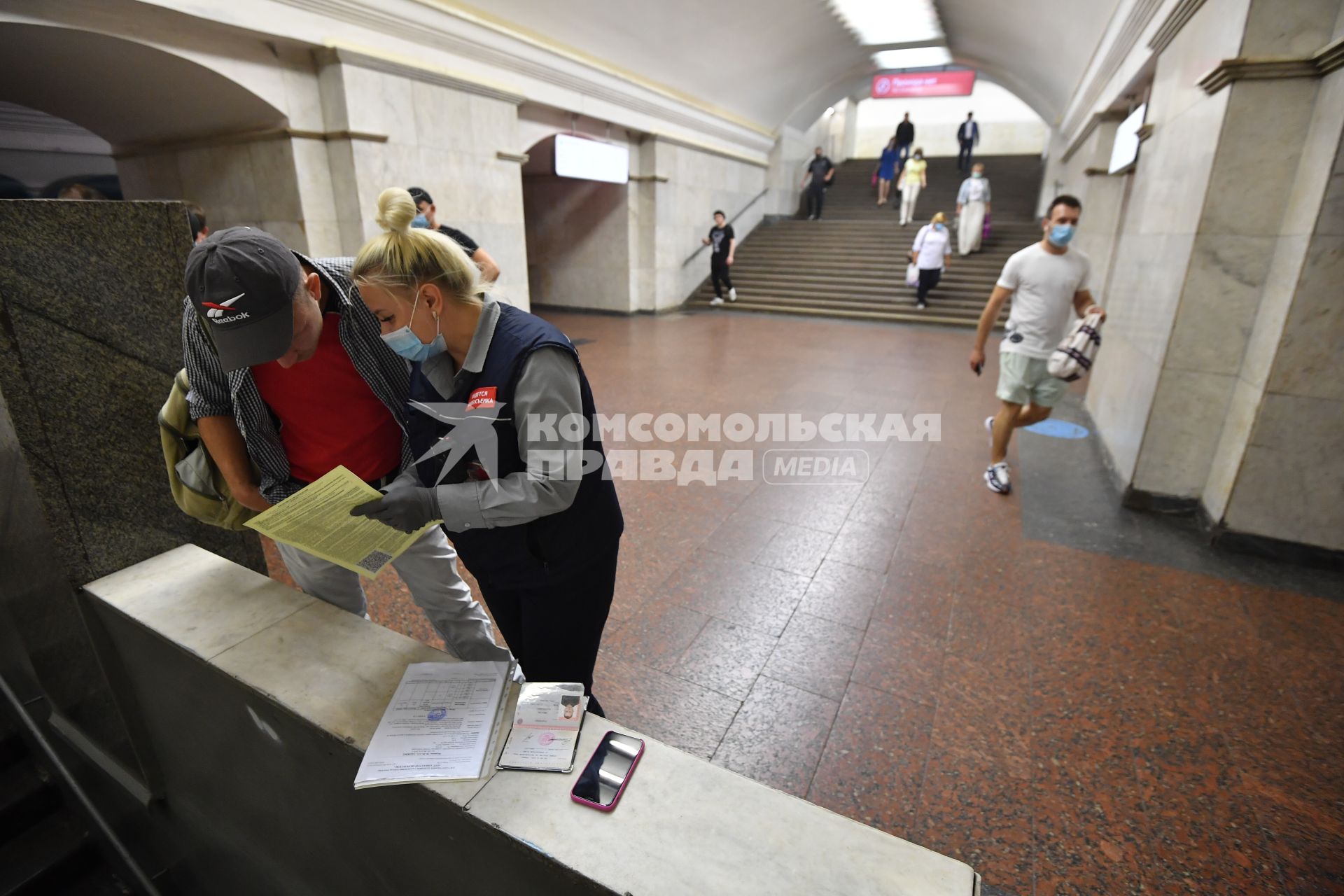 Москва.  Сотрудник метрополитена выписывает штраф пассажиру без медицинской маски.