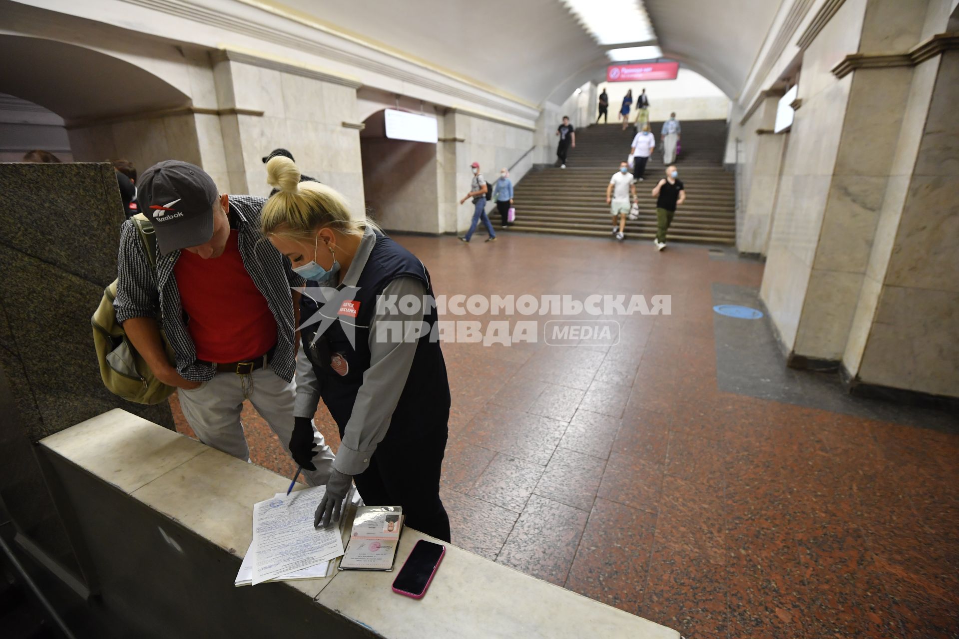 Москва.  Сотрудник метрополитена выписывает штраф пассажиру без медицинской маски.