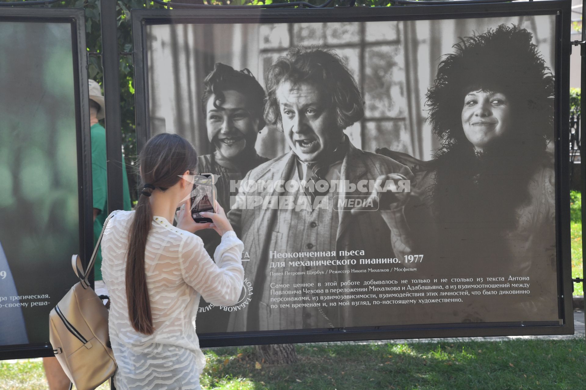 Москва.  Прохожие на открытии фотовыставки, посвященной 85-летию  Олега Табакова на Чистопрудном бульваре.