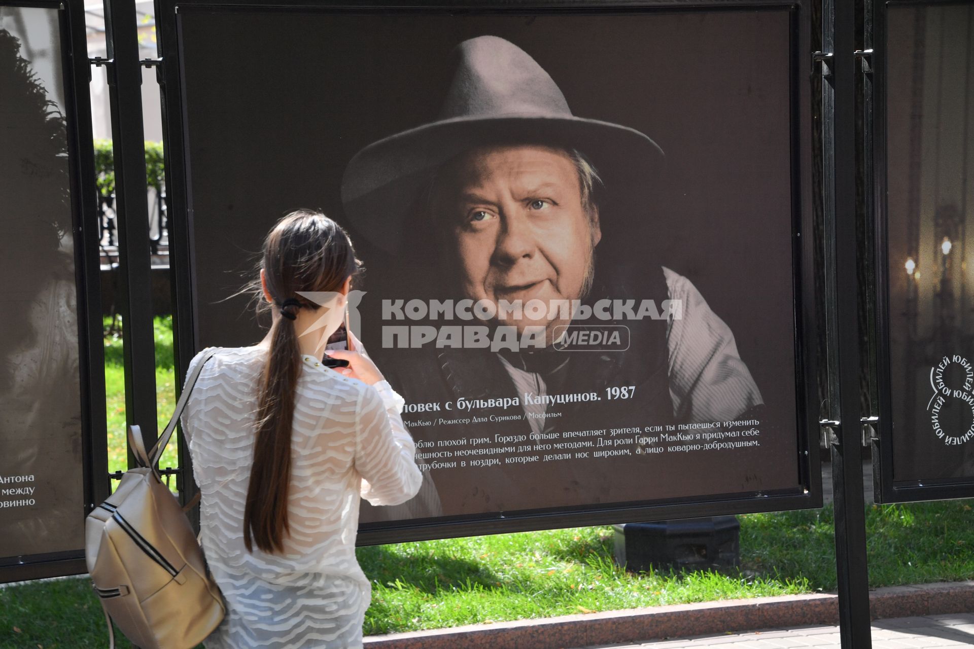 Москва.  Прохожие на открытии фотовыставки, посвященной 85-летию  Олега Табакова на Чистопрудном бульваре.