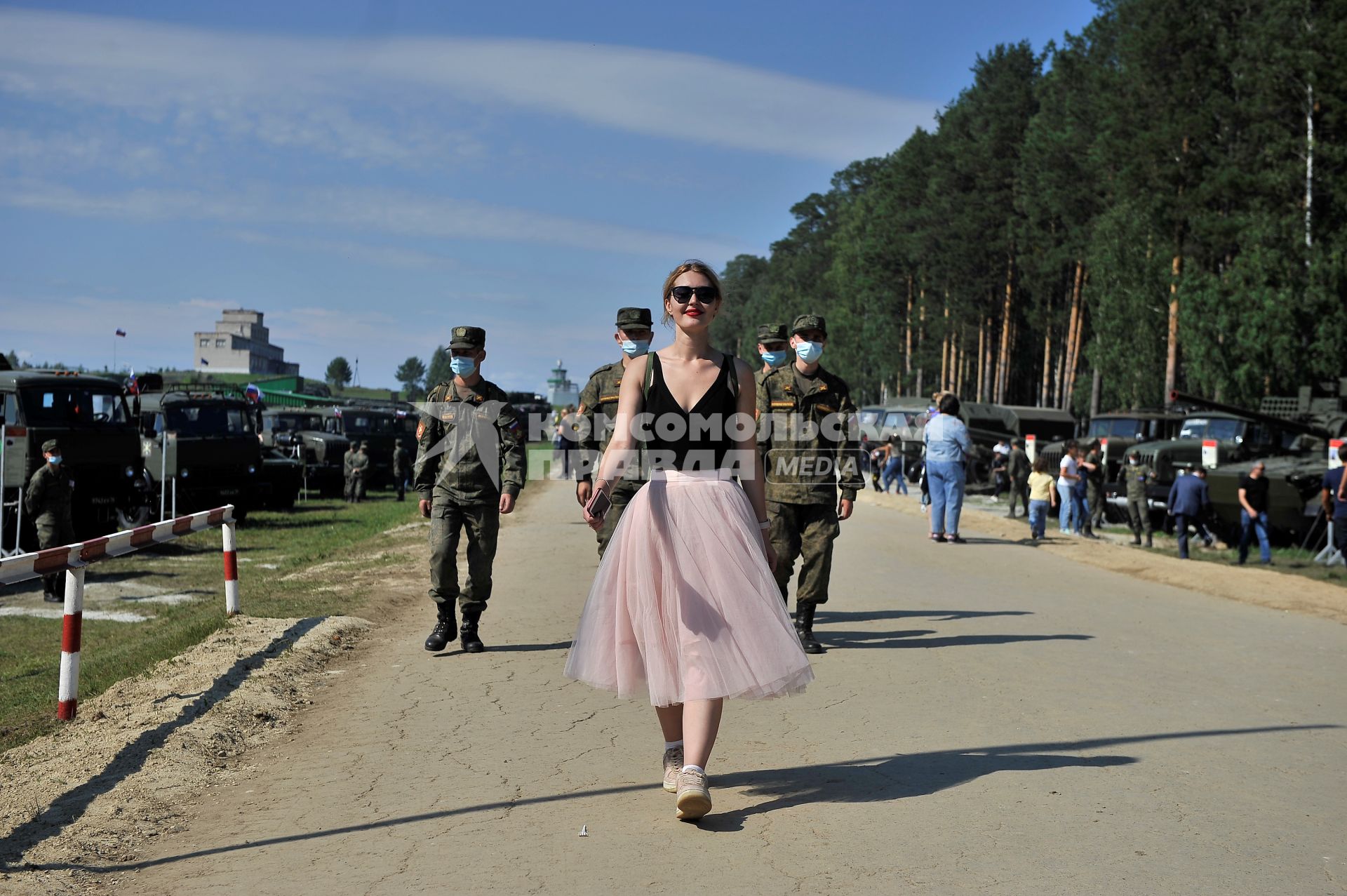 Екатеринбург. Танковый полигон 32-го военного городка. Международный военно-технический форум \'Армия-2020\'. Девушка идет перед военнослужащими