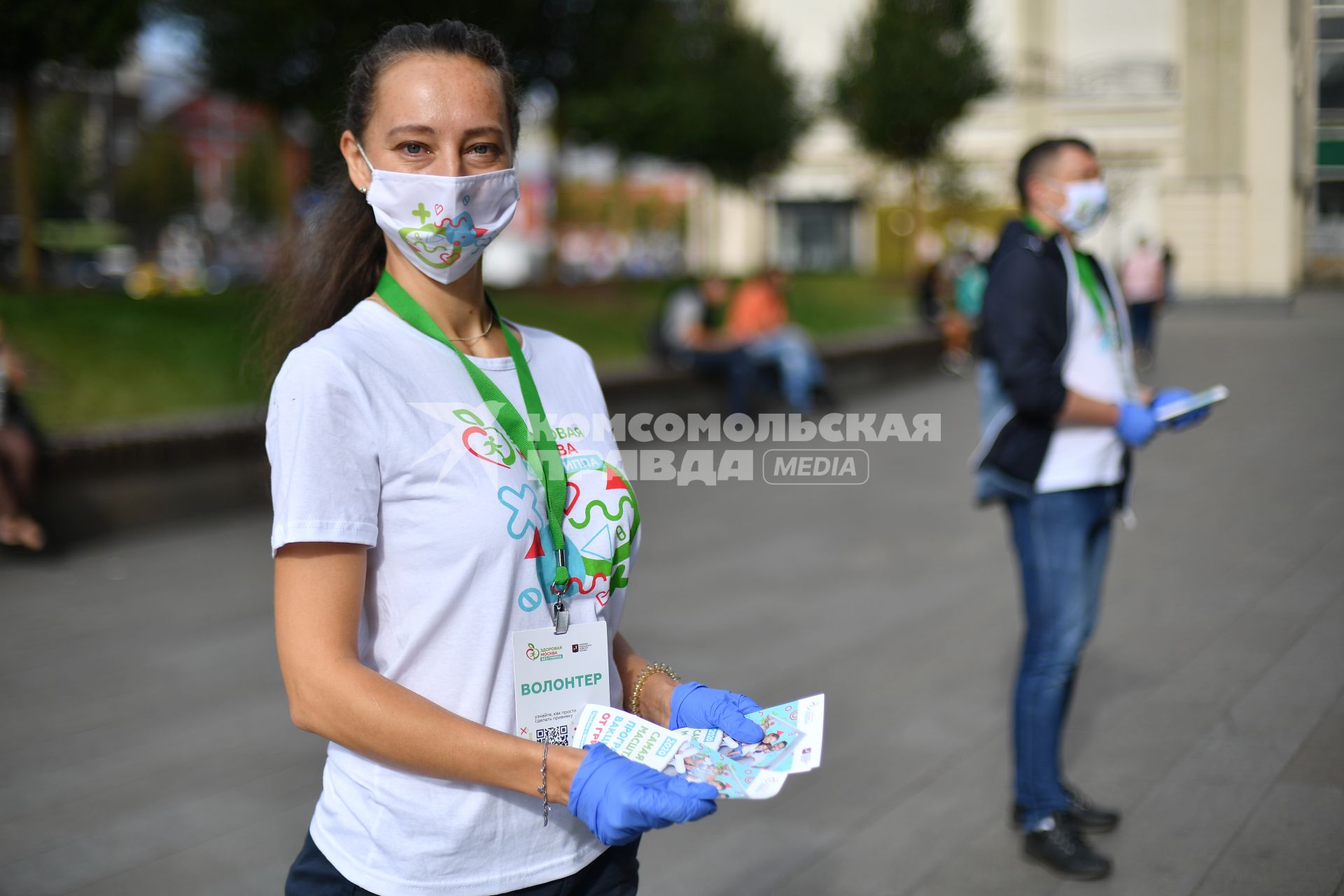 Москва.  Девушка-волонтер раздает листовки у мобильного пункта вакцинации на Пушкинской площади.