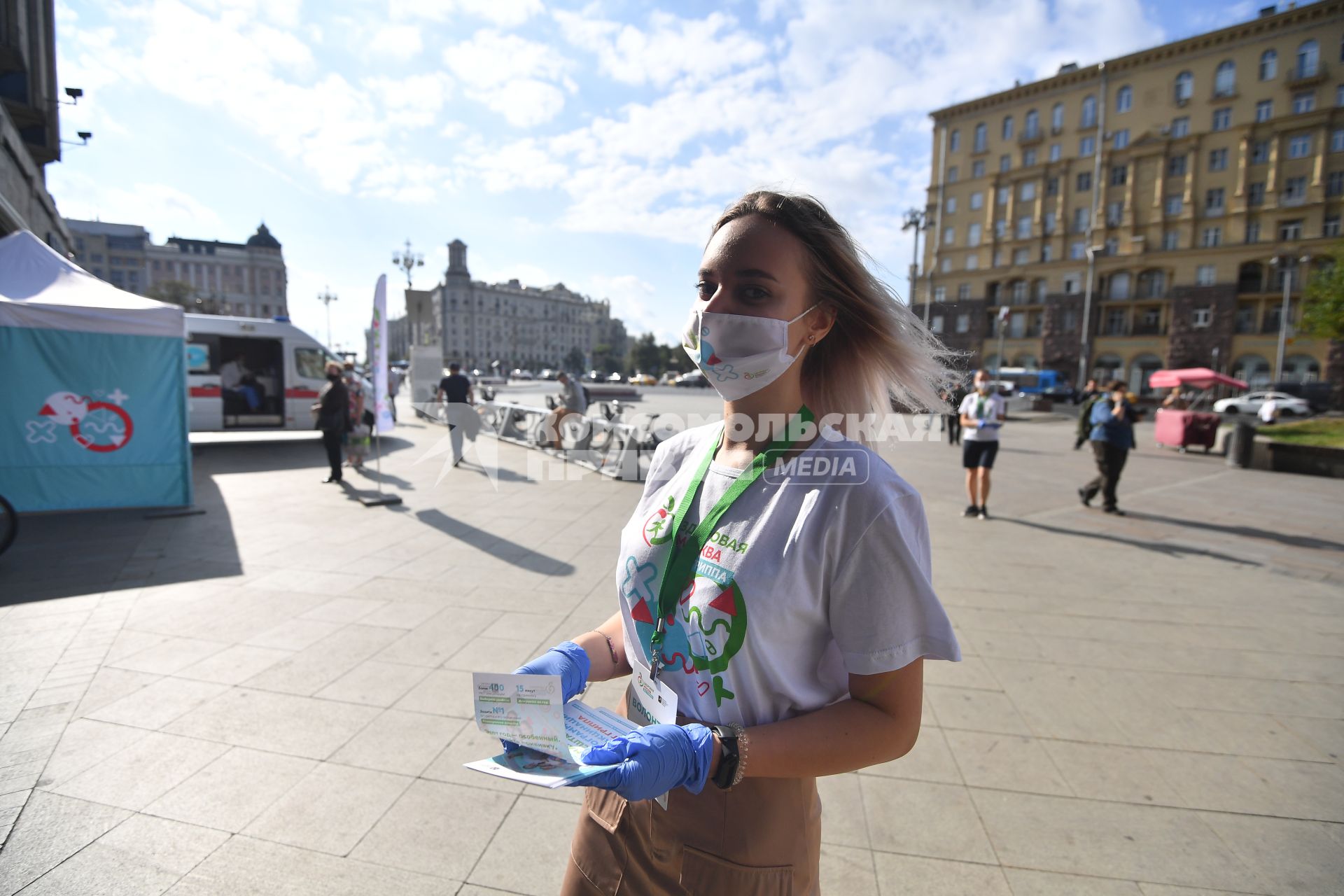 Москва.  Девушка-волонтер раздает листовки у мобильного пункта вакцинации на Пушкинской площади.