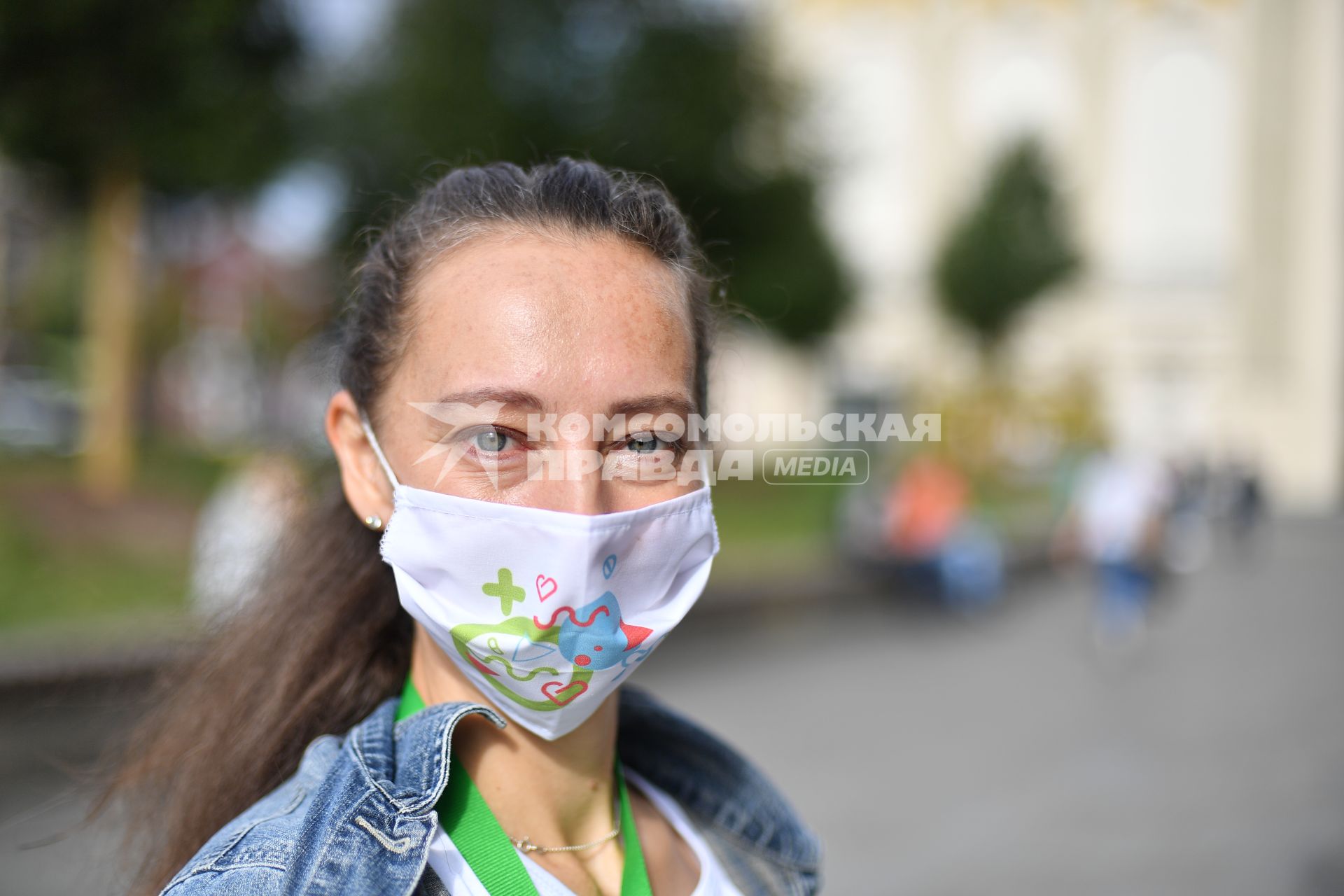 Москва.  Девушка-волонтер раздает листовки у мобильного пункта вакцинации на Пушкинской площади.