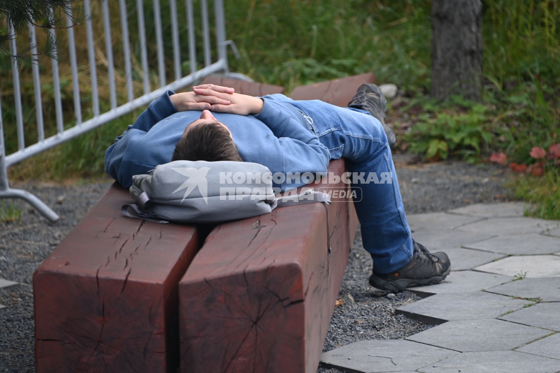 Москва.  Юноша на скамейке в парке Зарядье.