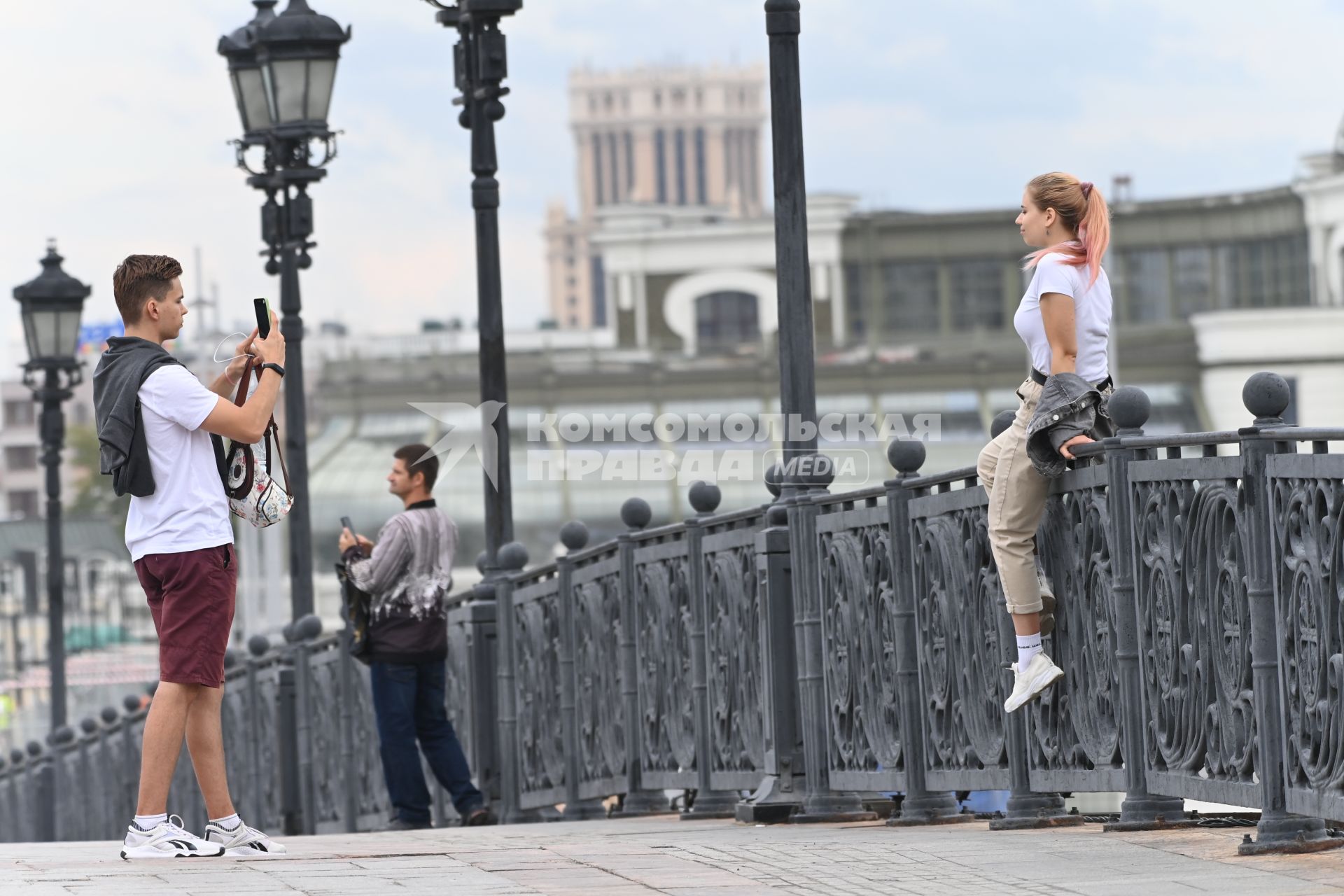 Москва.   Молодые люди фотографируются на Патриаршем мосту.