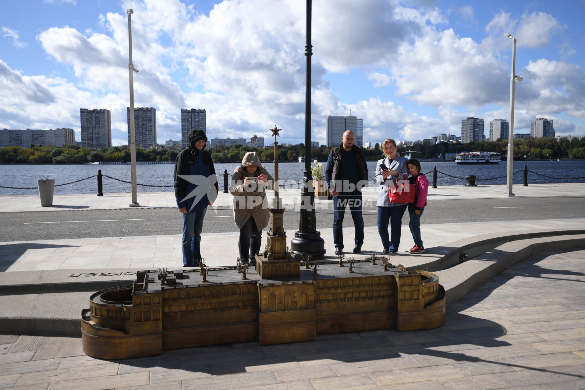 Москва. Люди фотографируют макет Северного Речного вокзала, расположенный на набережной.
