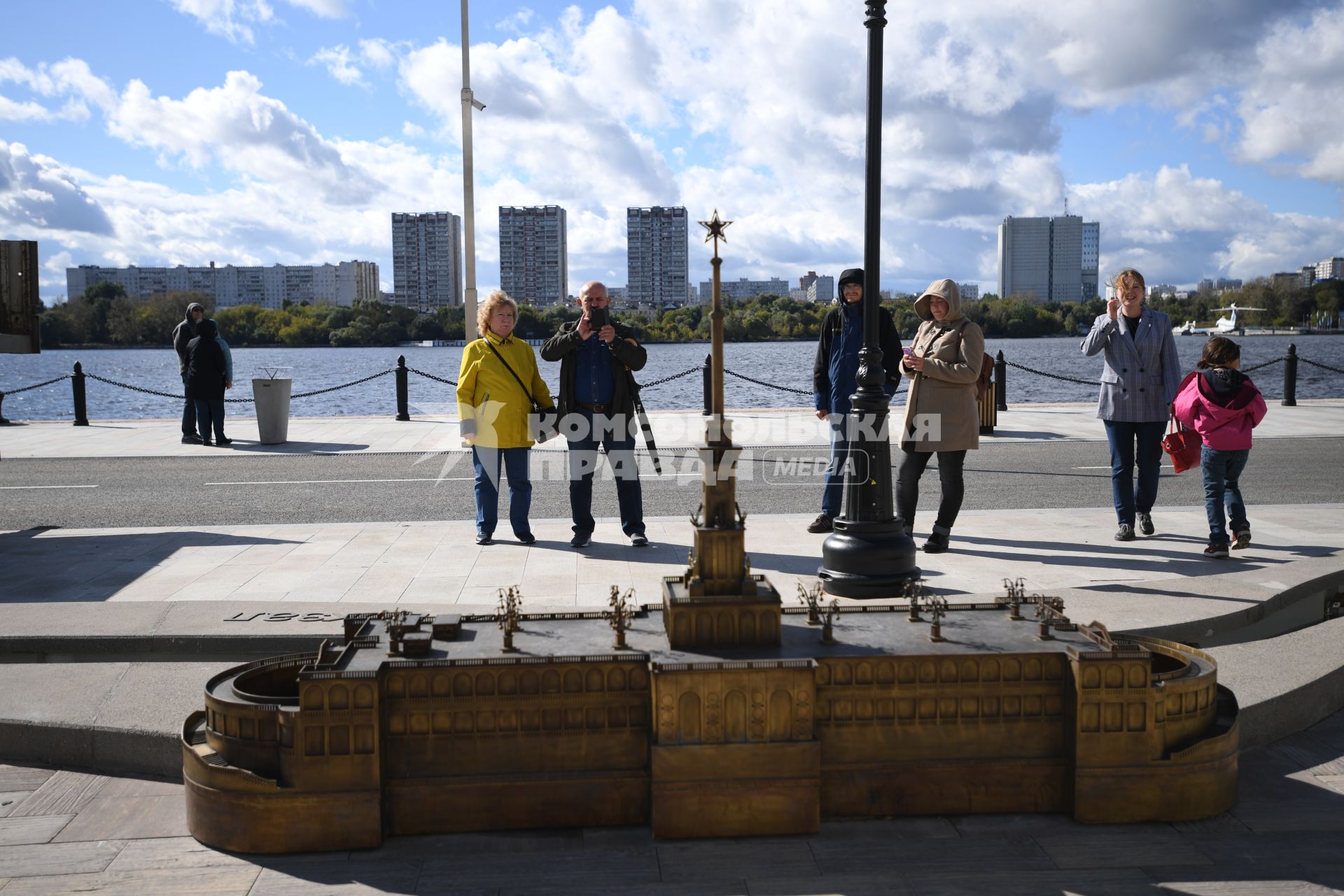 Москва. Люди фотографируют макет Северного Речного вокзала, расположенный на набережной.