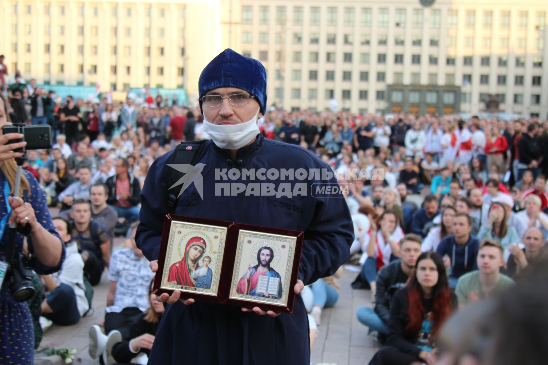 Минск. Священник держит иконы во время митинга против результатов выборов президента Белоруссии на площади Независимости, где расположены здания правительства и ЦИК.