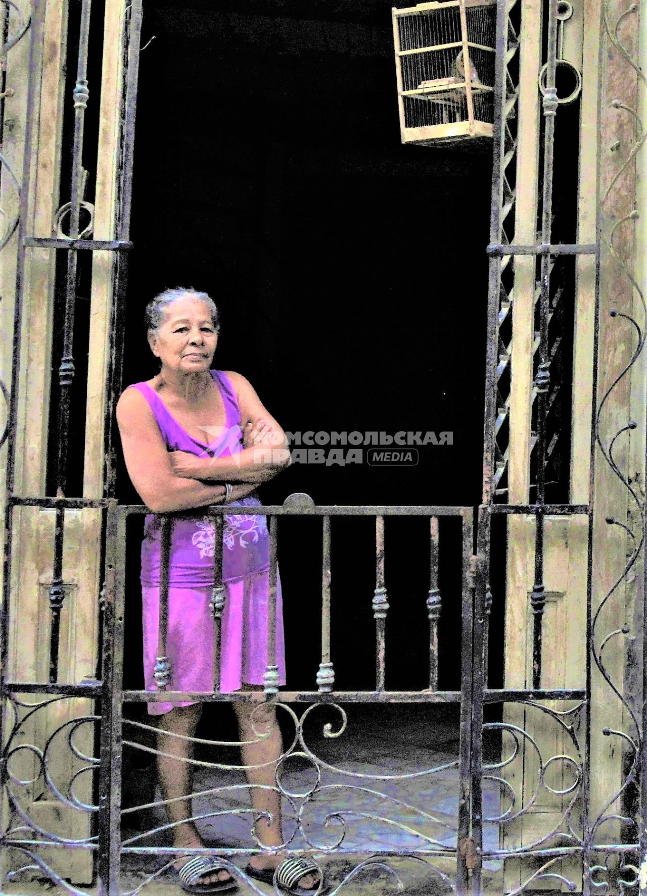 Куба. Гавана. Местная жительница стоит на балконе.