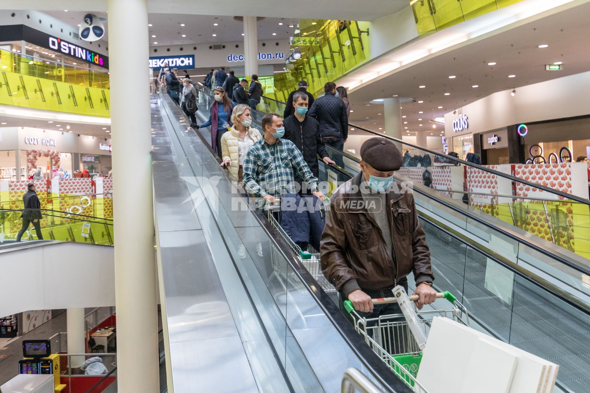 Москва.  Покупатели в защитных масках  на эскалаторе  магазина.